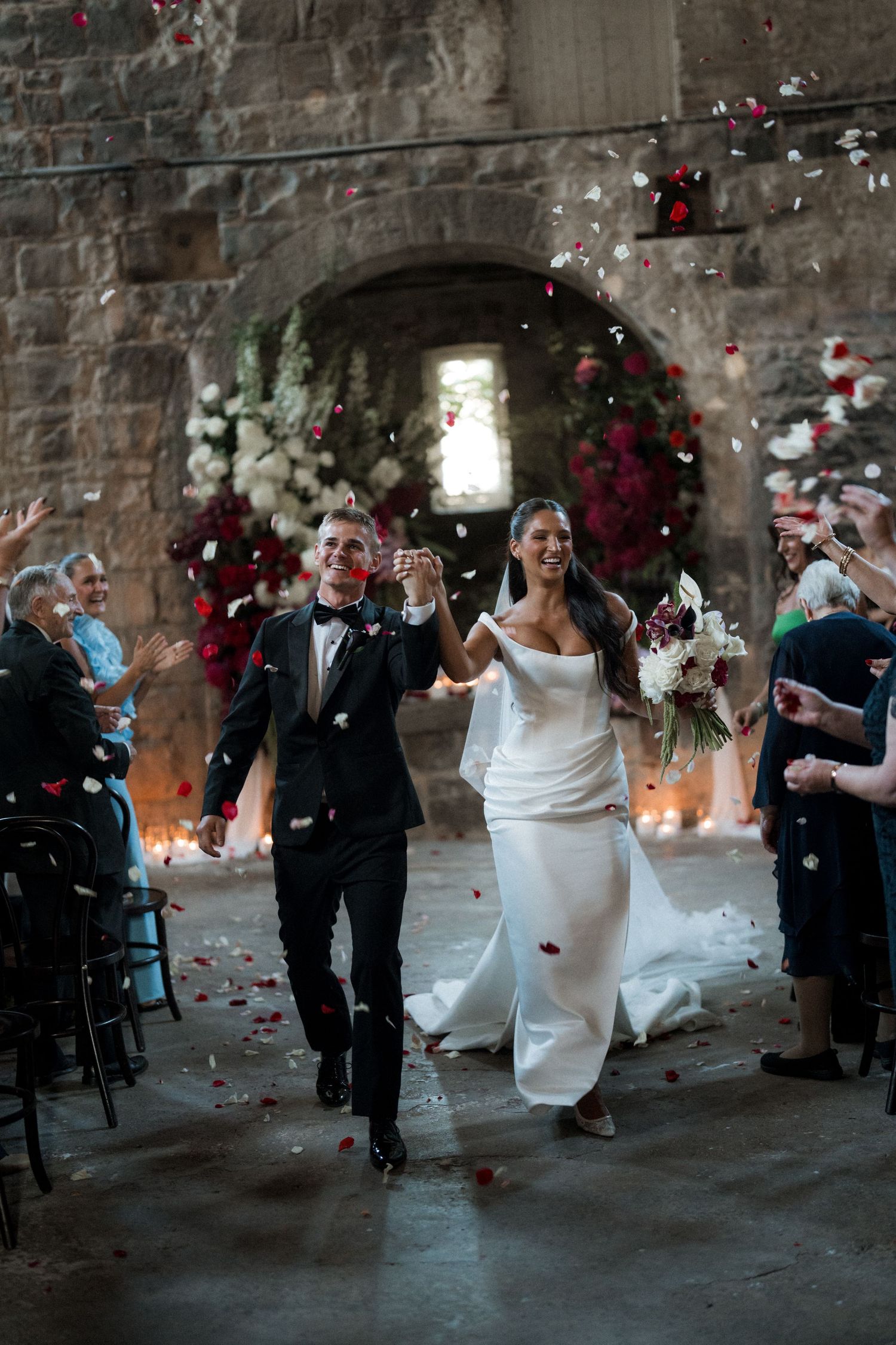 Wedding party celebration in a rustic brick venue with confetti and dancing.