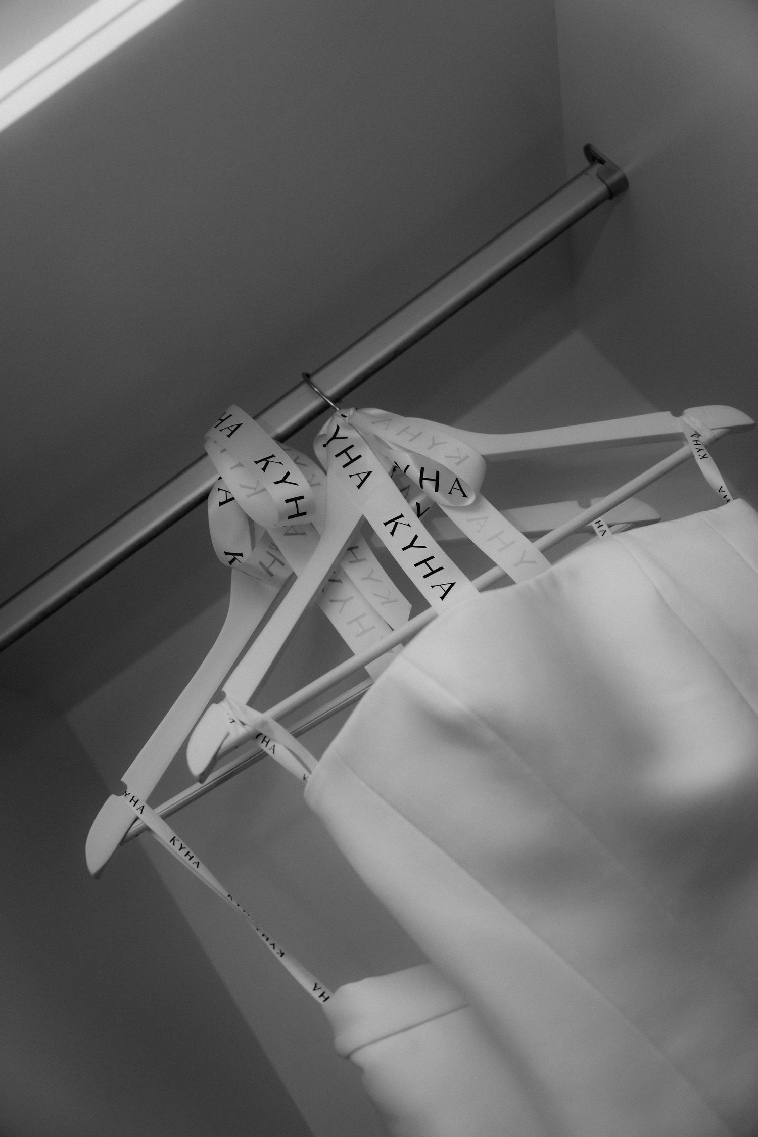 Black and white wedding dress hangers with text displayed in a row against a light background.