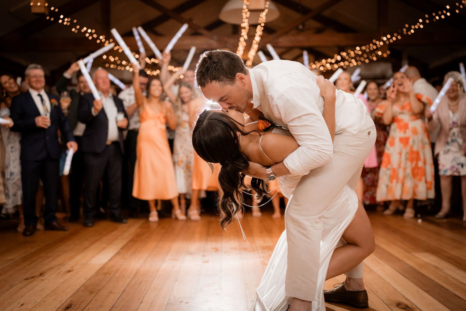 Wedding reception dance floor with string lights overhead and guests dancing.