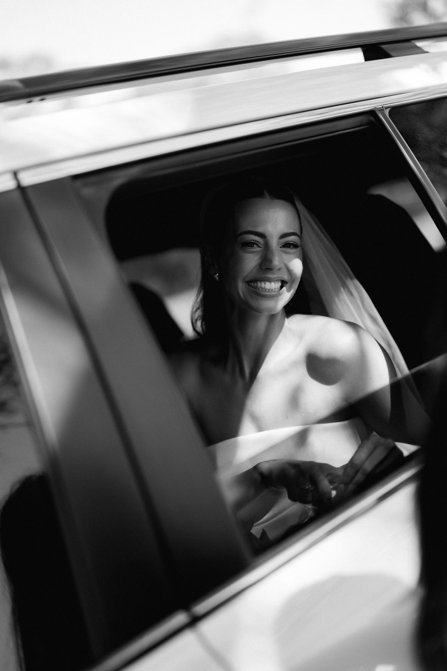 Black and white photo of a luxury car window on a wedding day.