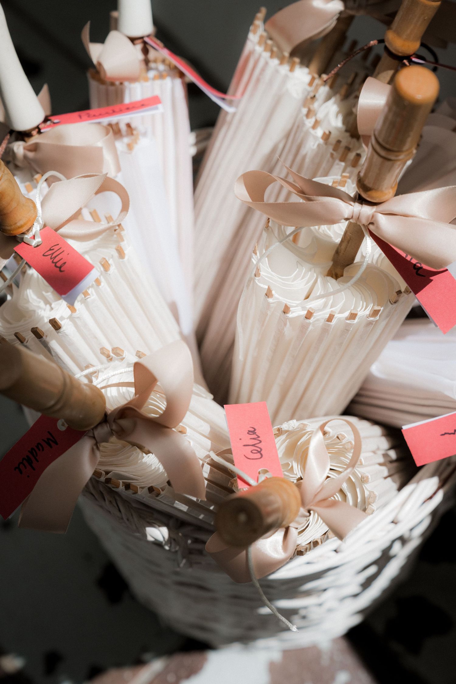 Wedding place cards and name tags arranged artistically in a white vessel.