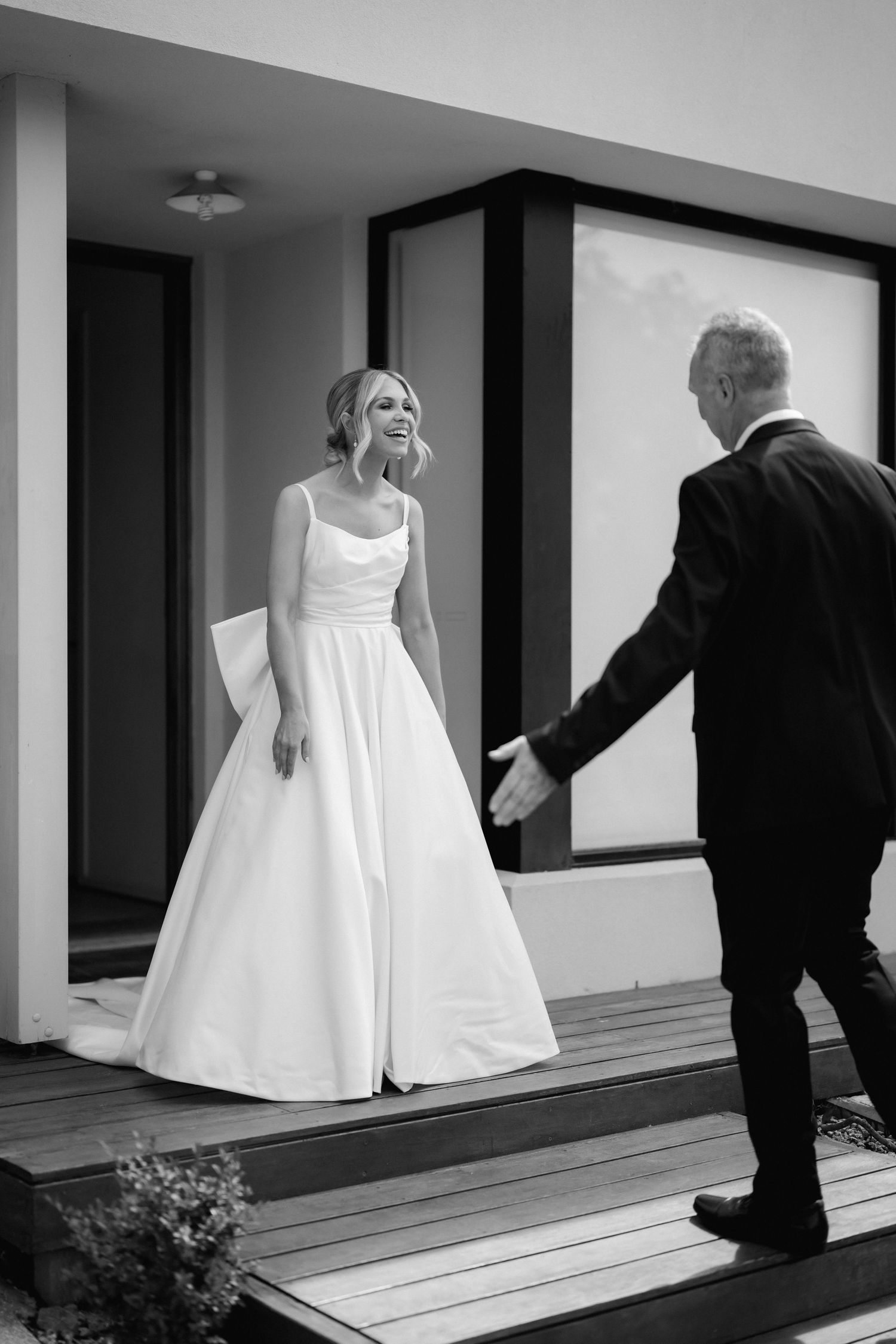 Black and white series showing movement of a flowing white wedding dress on outdoor deck.