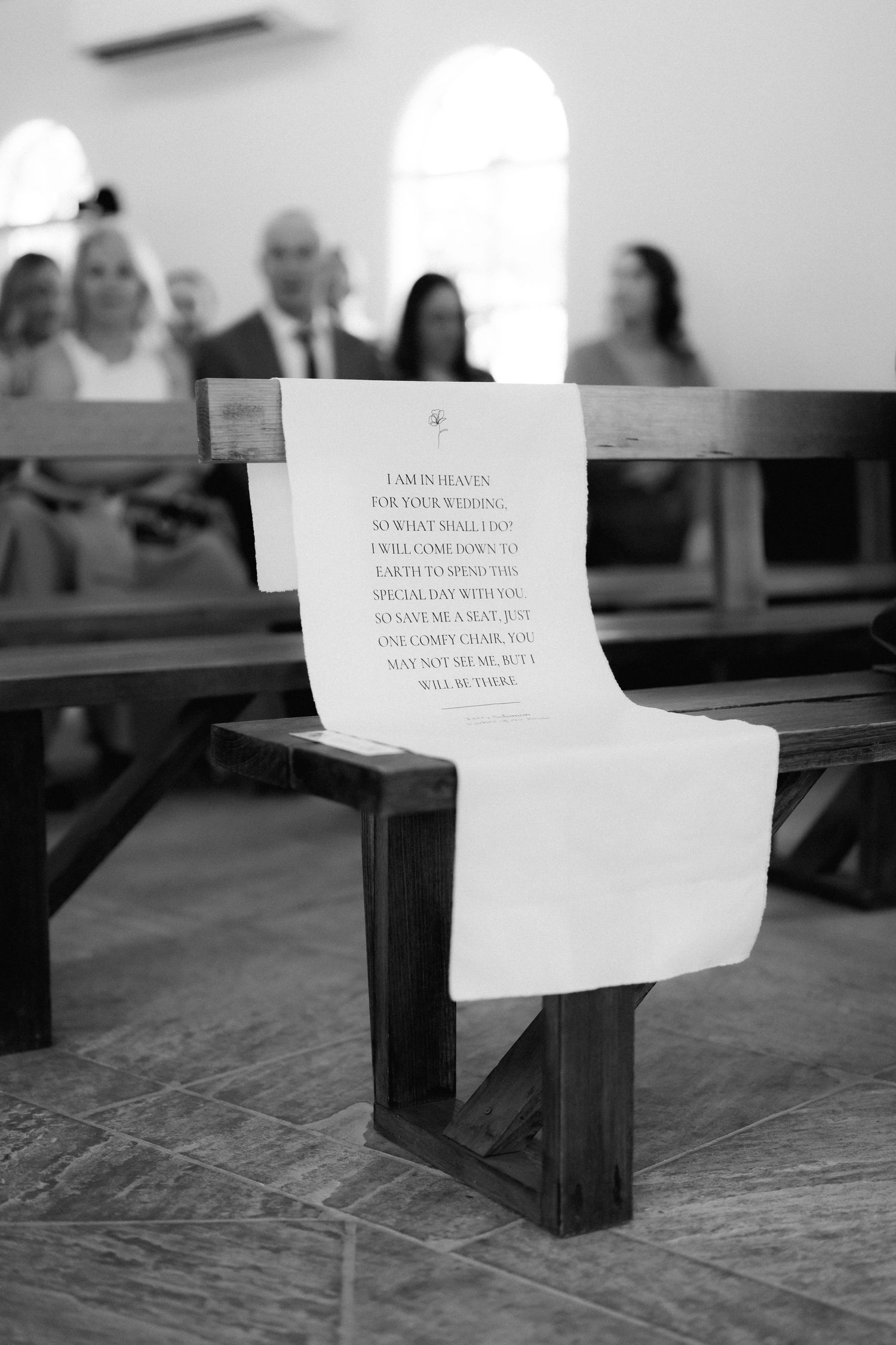 Black and white photo of paper notes placed on wooden church pews.