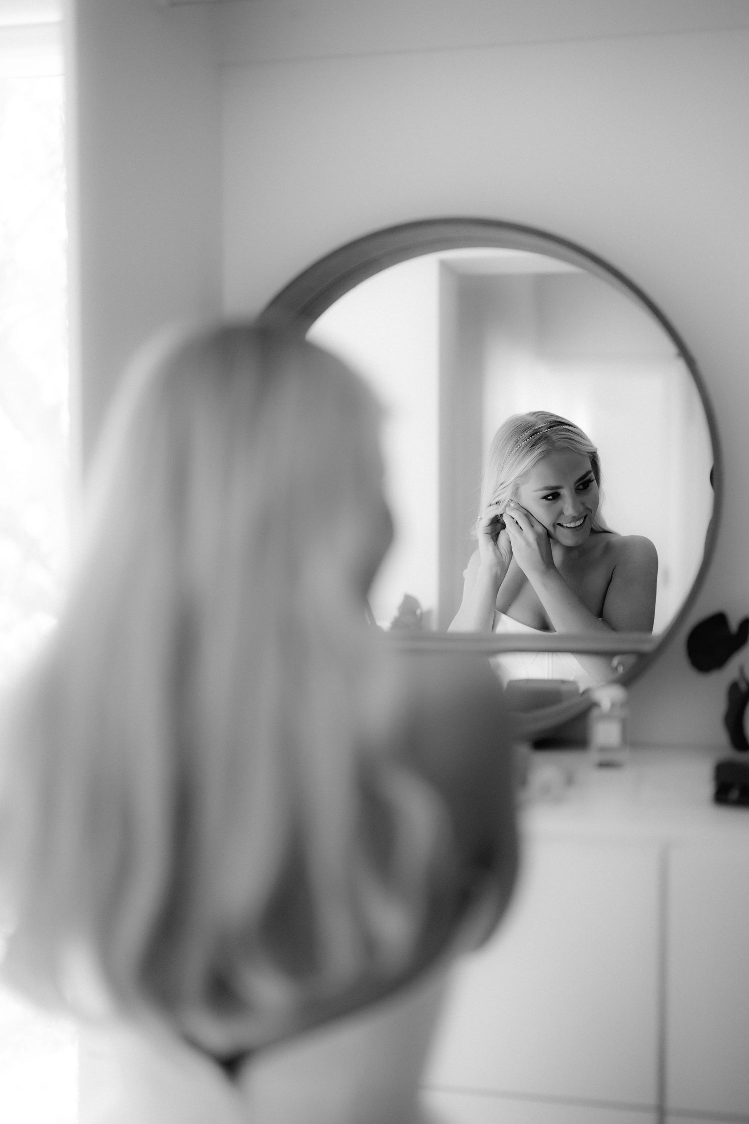 Black and white reflections in a series of mirrors show a bride getting ready for her wedding day.