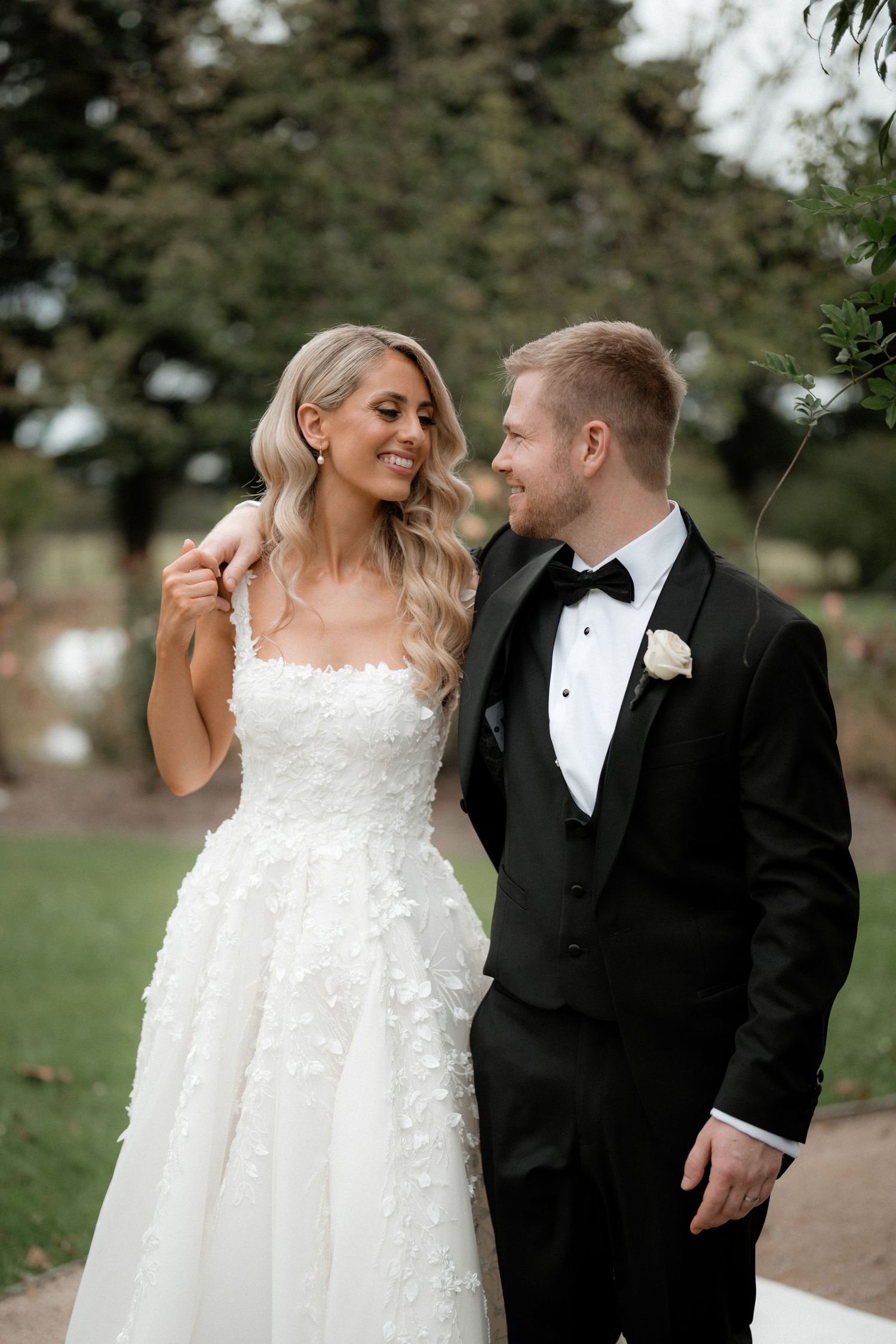 Romantic outdoor portrait of a couple in wedding attire sharing a sweet moment.