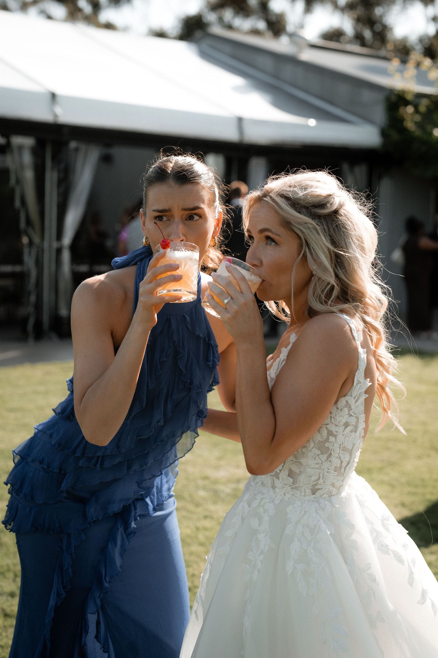 Wedding party members sharing drinks and celebrating during outdoor reception.