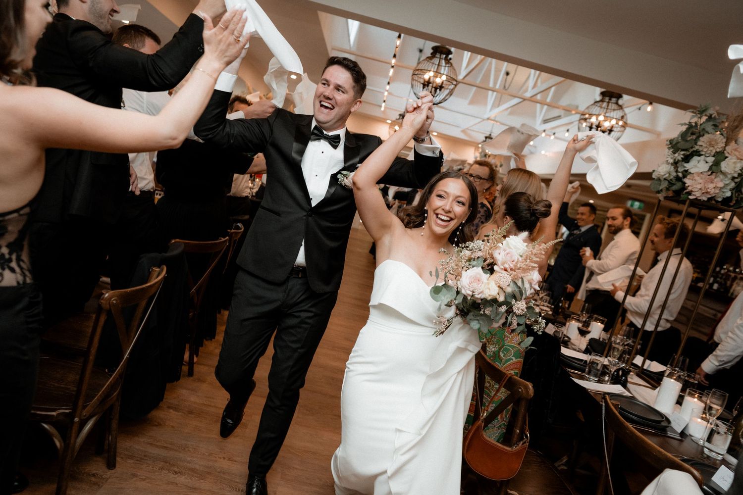 Newlyweds make their grand entrance at reception while guests cheer them on with sparklers.