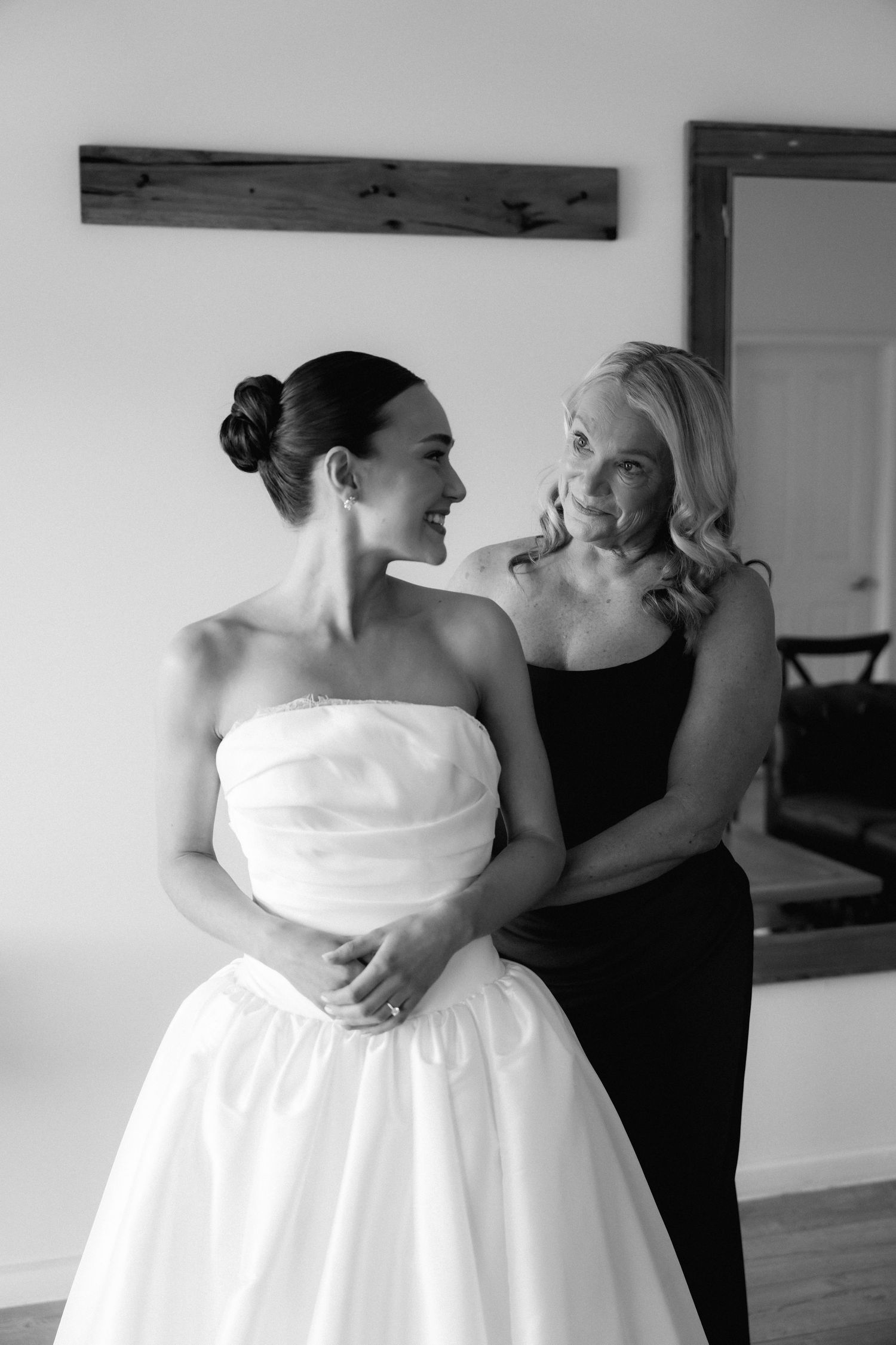 A couple embraces in a tender moment while wearing formal wedding attire.
