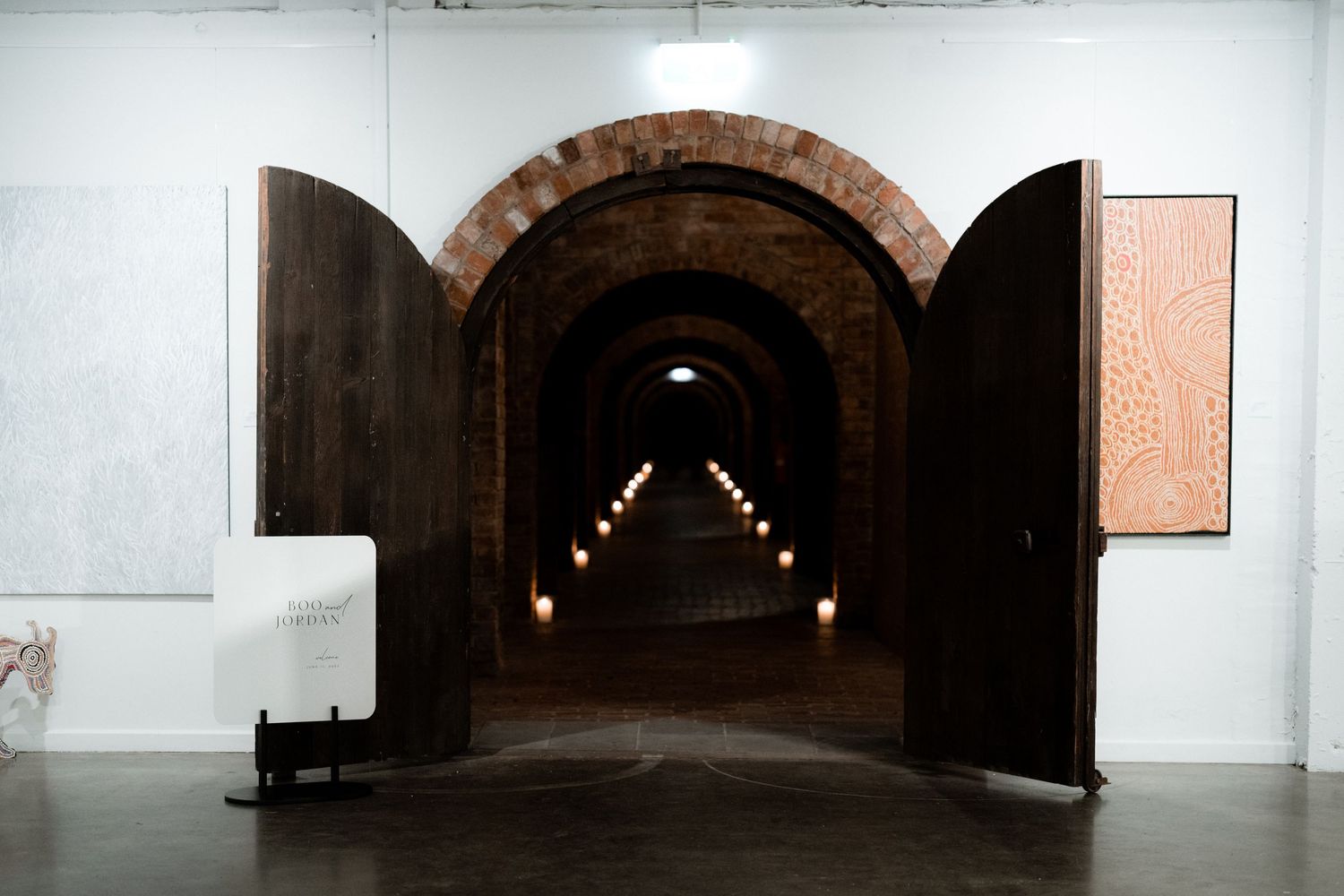 Long tunnel corridor with arched doorway and dramatic lighting creating depth perspective.