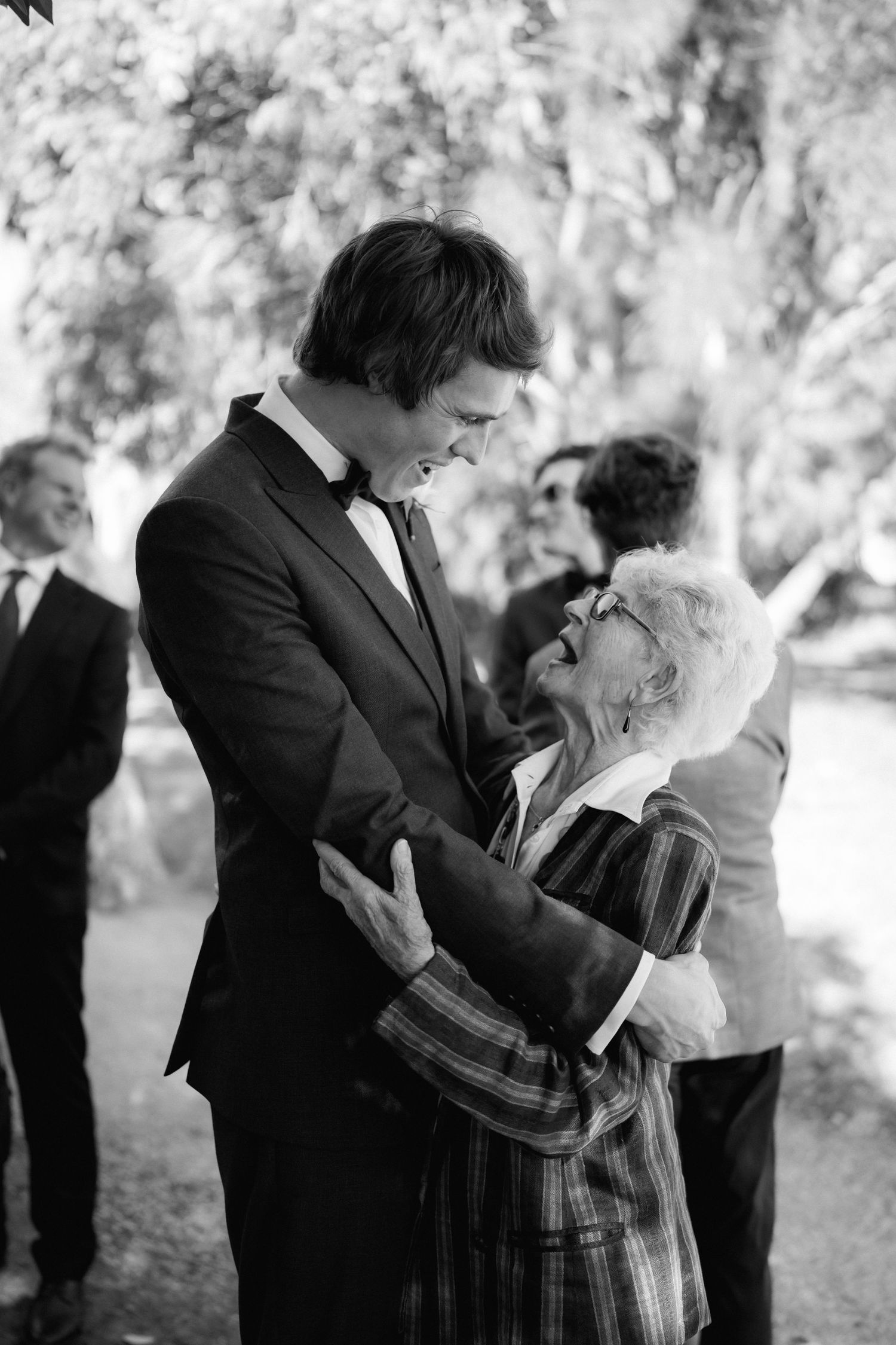 Black and white photo showing tender moment during wedding celebration.