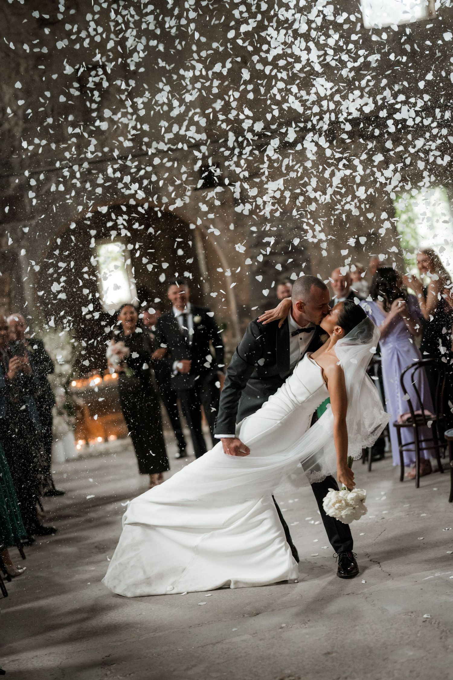 A romantic wedding dip kiss sequence with confetti falling as the couple celebrates their special moment.
