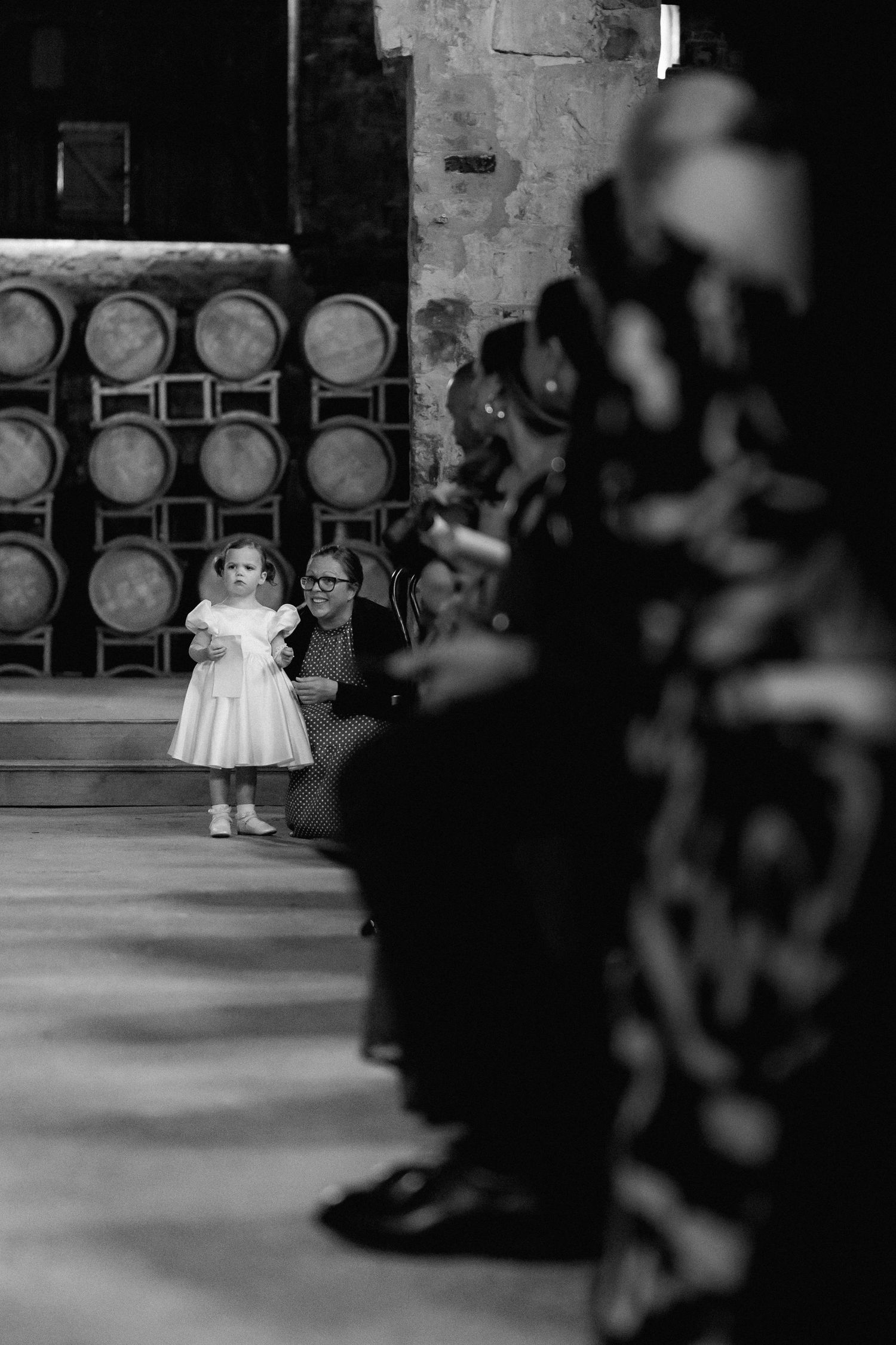 Blurred artistic wedding photo with wine barrels in background.