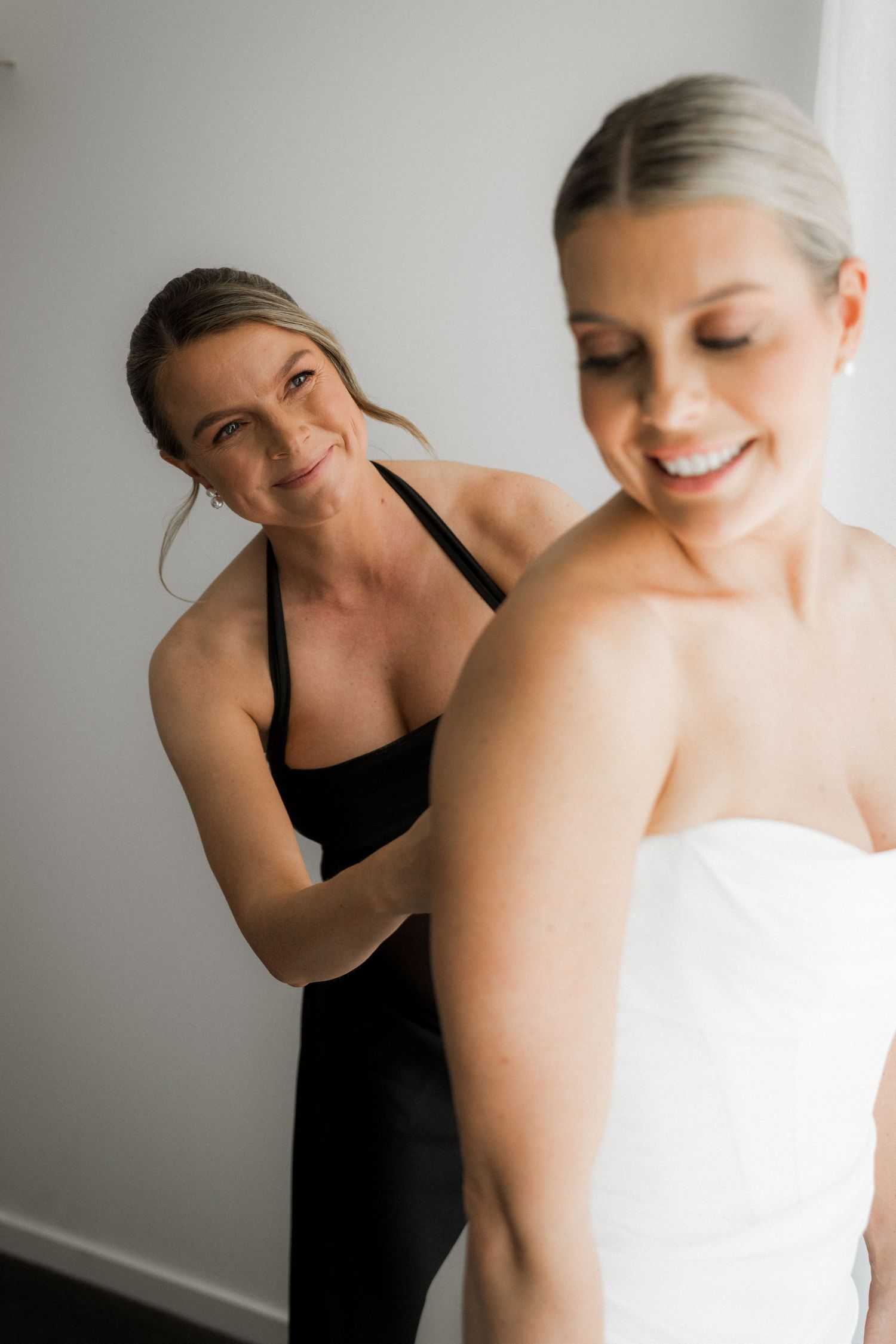 Two people share an intimate candid moment against a white background during a photoshoot.