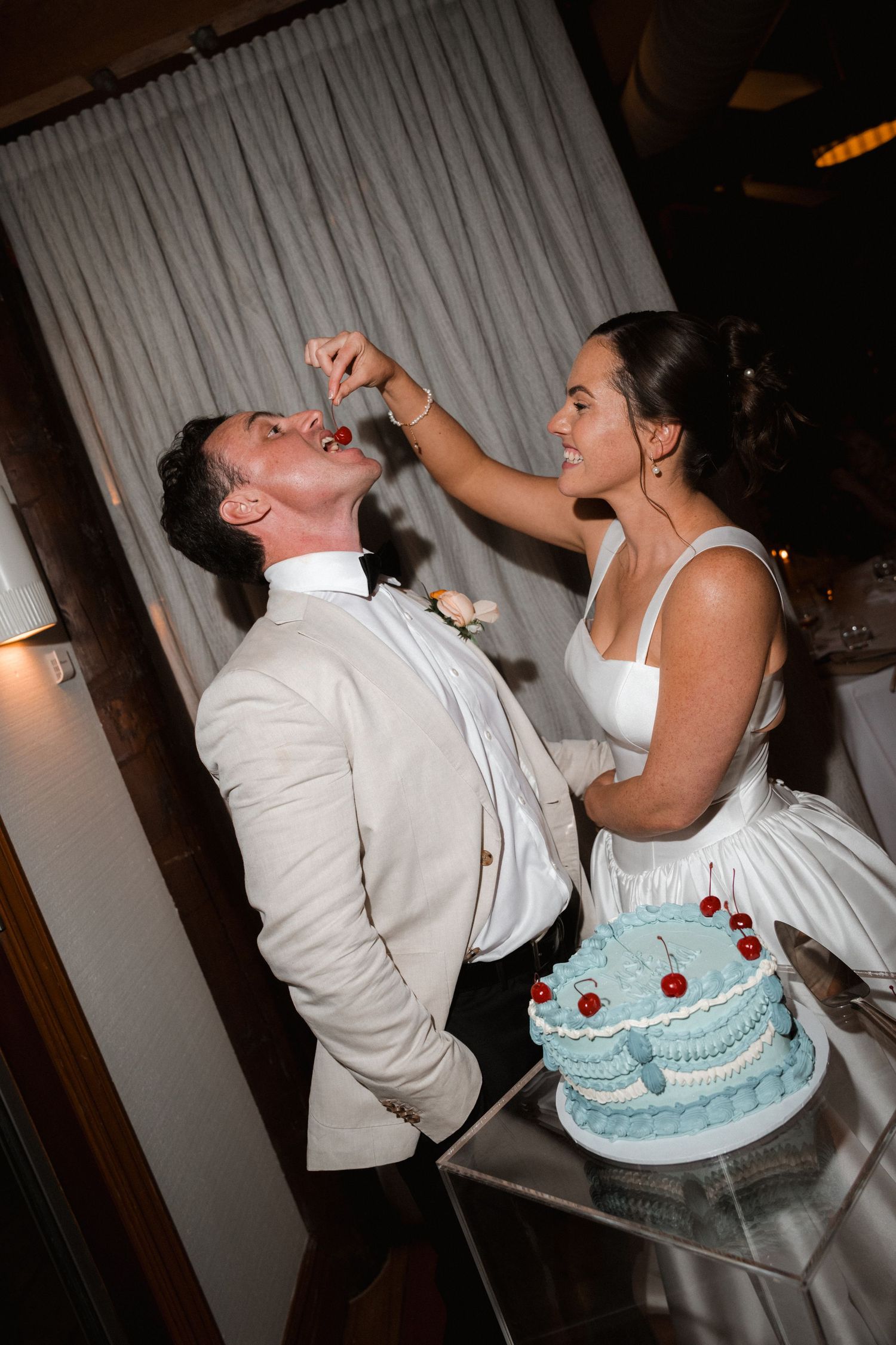 Wedding cake feeding sequence showing playful moments between newlyweds.