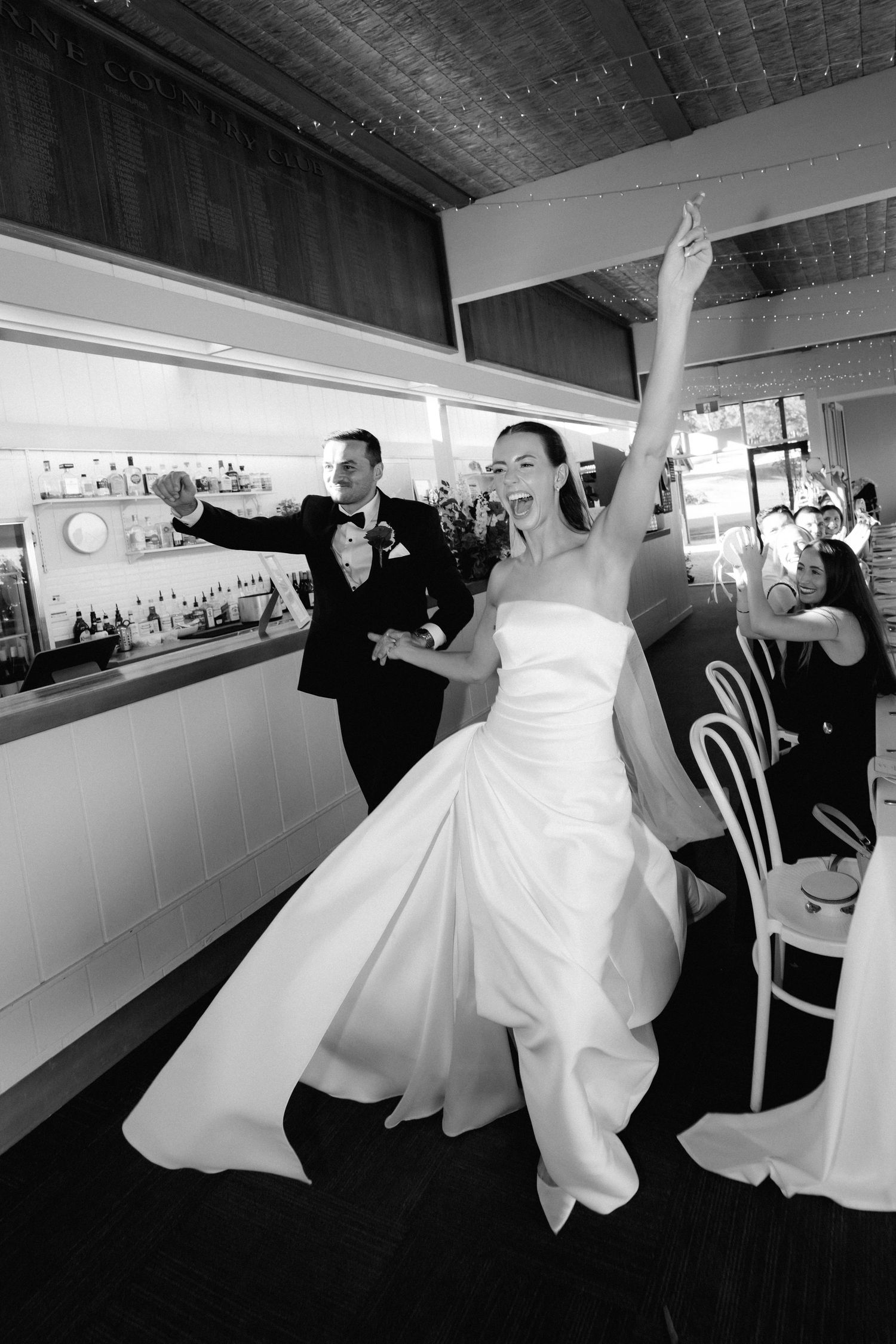 Black and white sequence showing wedding couple dancing and twirling in a reception venue.