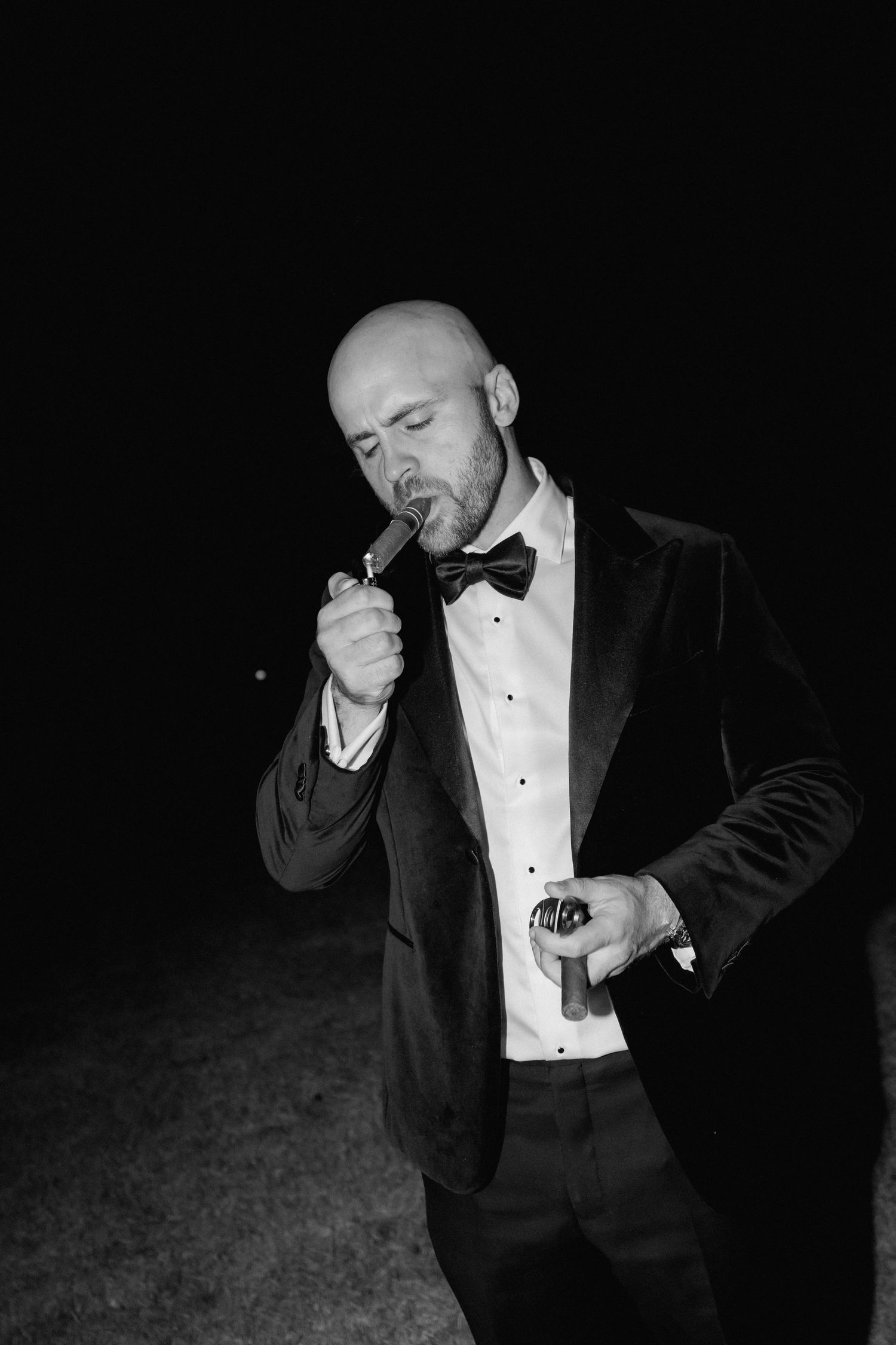 A series of black and white photos showing a person in a tuxedo smoking a cigar at night.