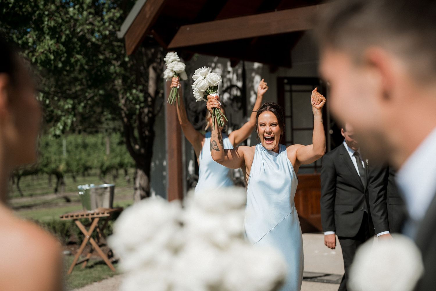 Candid outdoor wedding party moments with natural greenery backdrop.