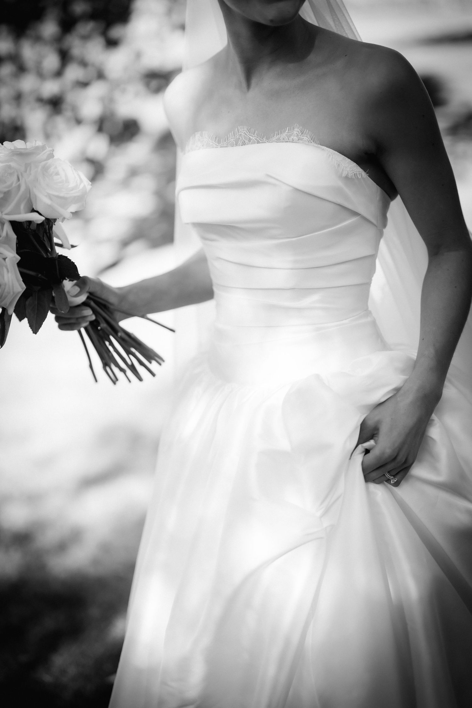 Series of artistic black and white shots showing details of a strapless wedding gown.