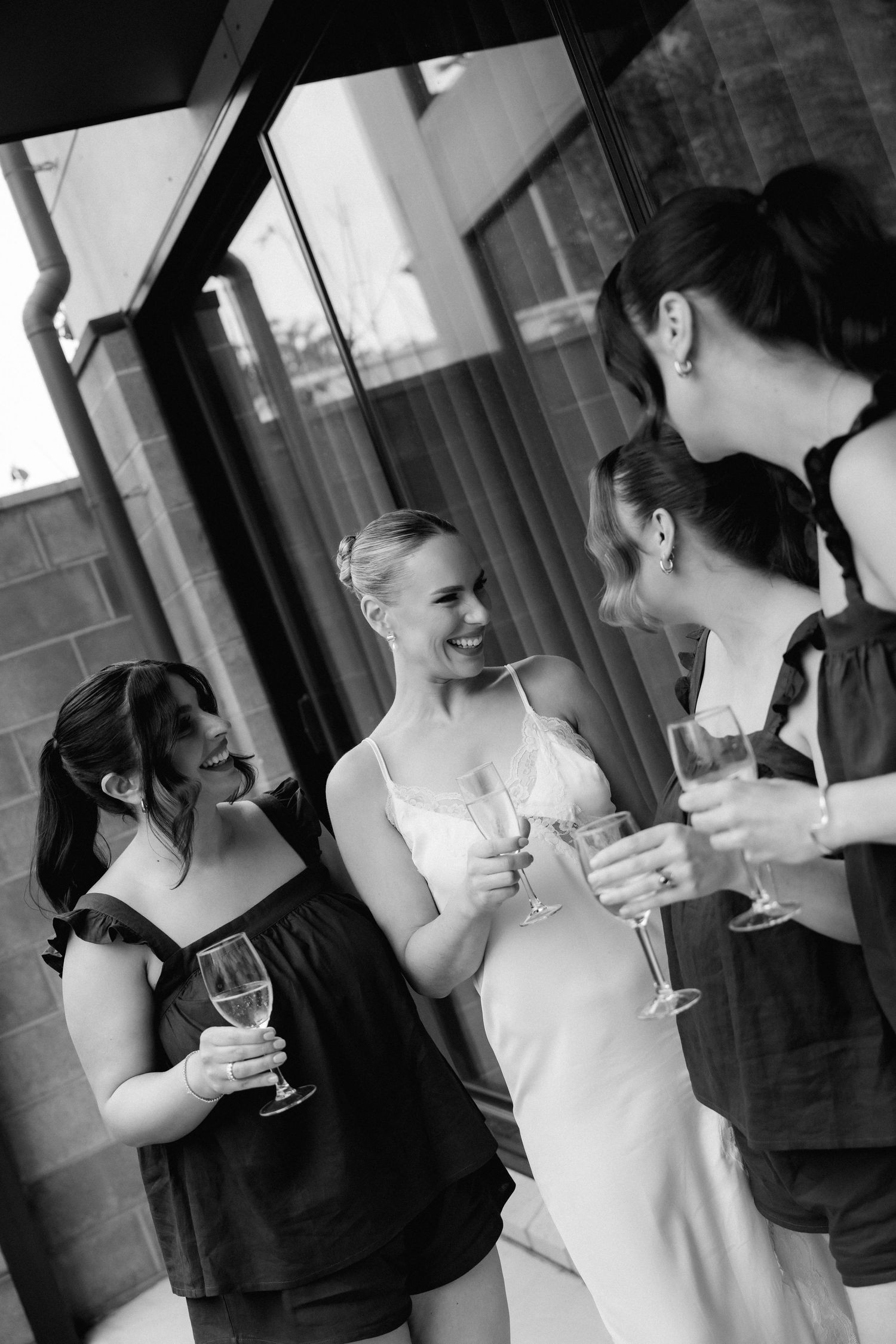 A series of candid black and white photos showing wedding guests sharing drinks and laughter.