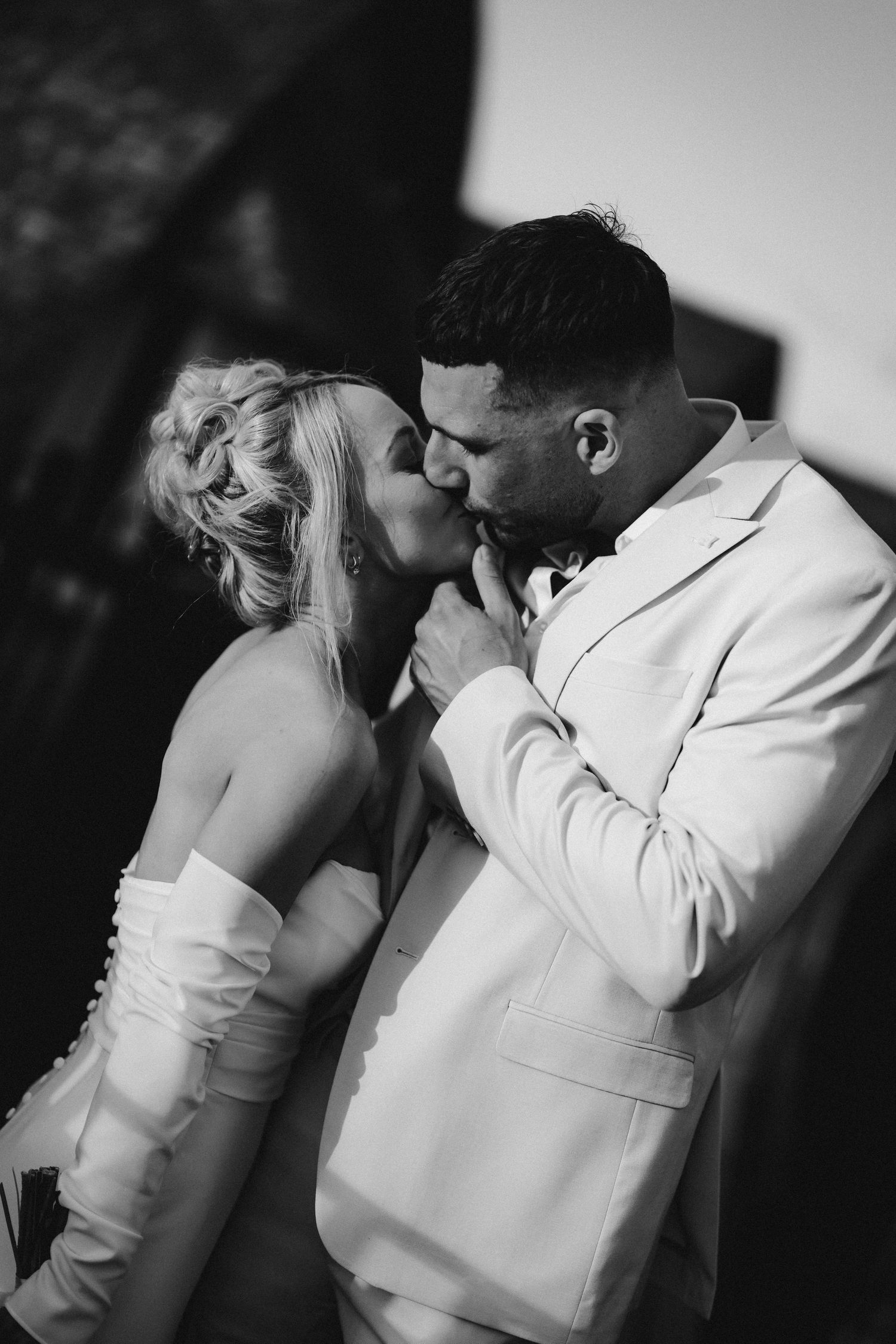 Wedding couple shares an intimate black and white portrait moment in formal attire.