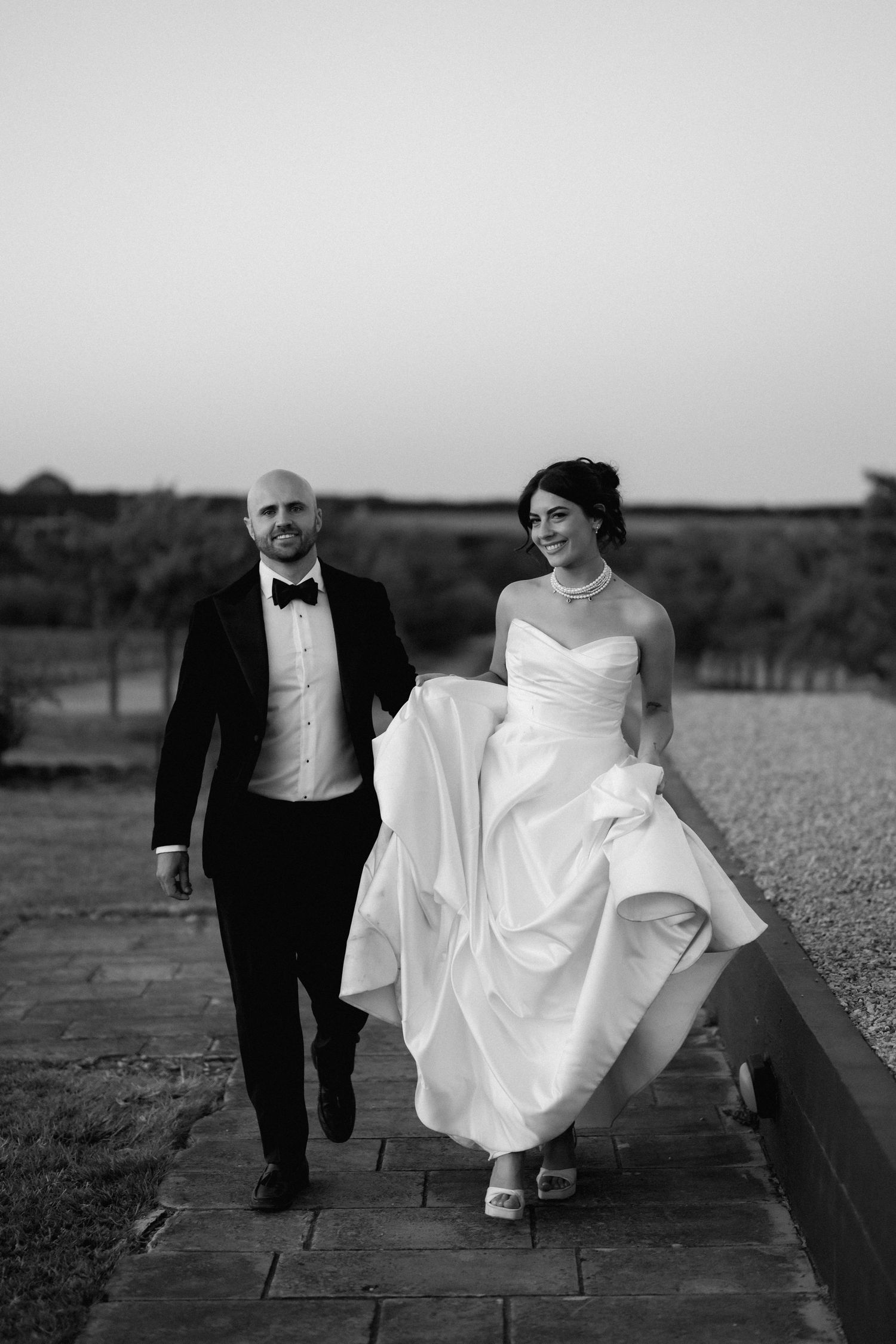 Black and white sequence of newlyweds walking and sitting on wooden boardwalk.