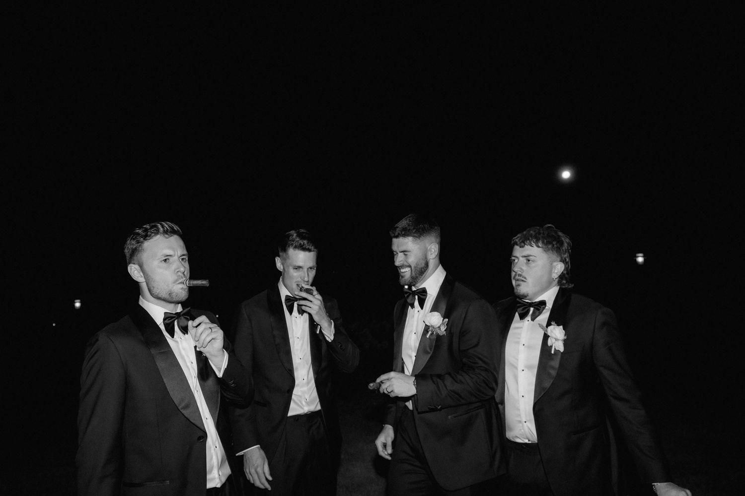 Black and white photograph of performers in formal attire on stage during a theatrical production.