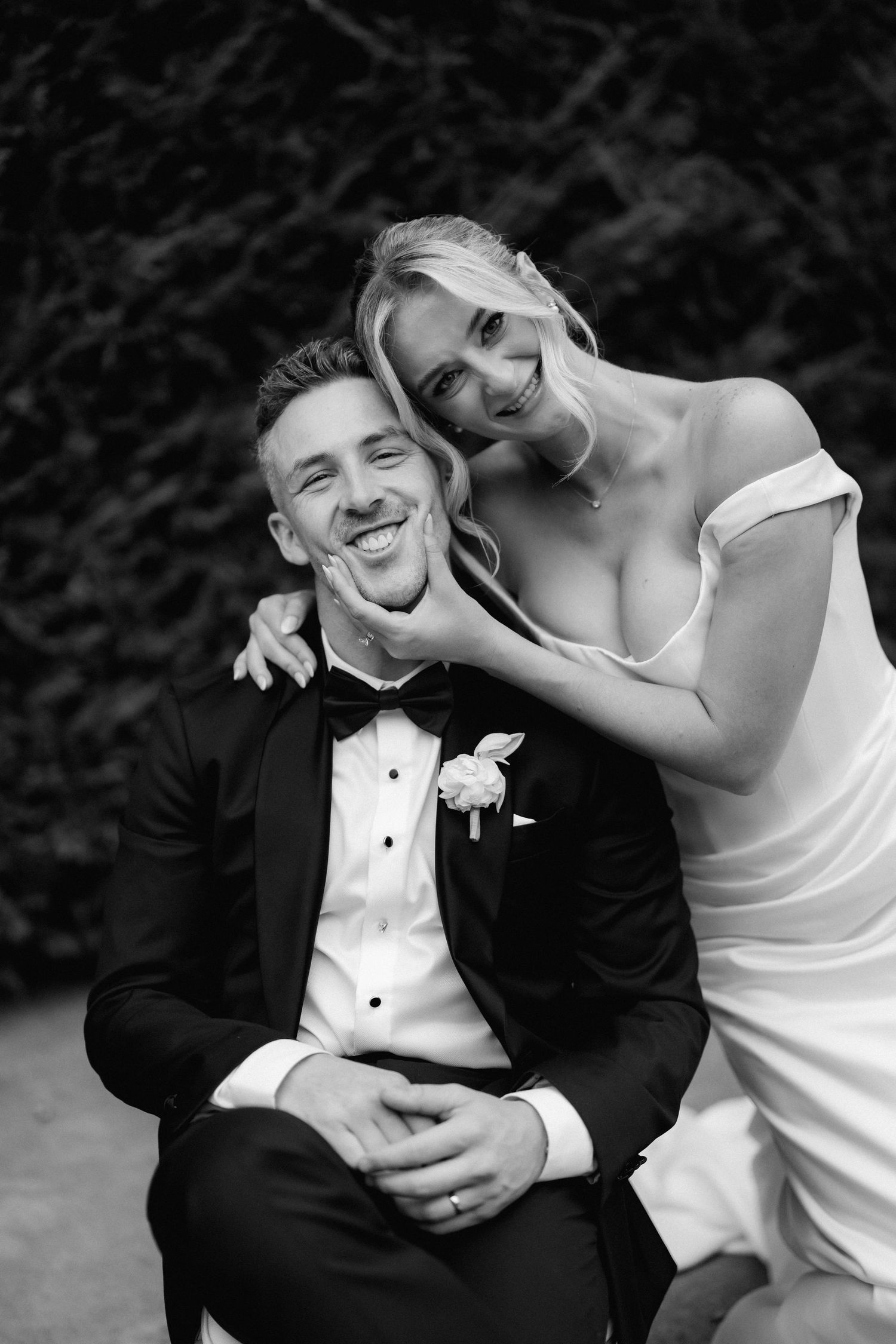 Candid black and white portrait of newlyweds sharing a laugh together.