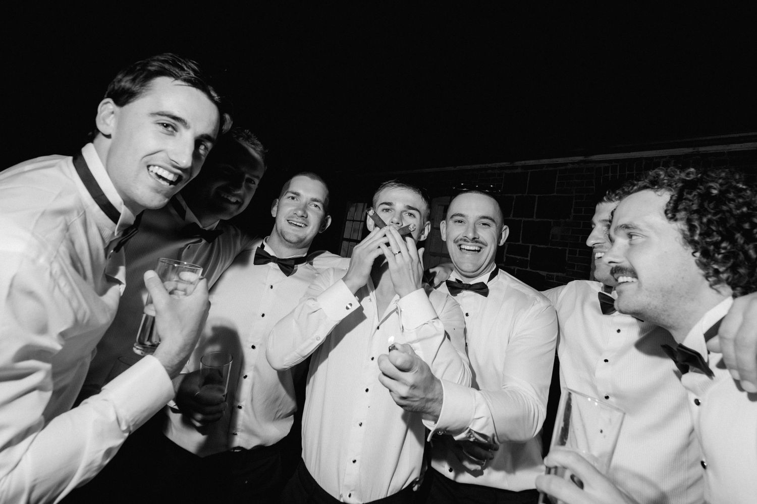 A black and white collage strip showing people laughing and enjoying themselves at what appears to be a formal event.