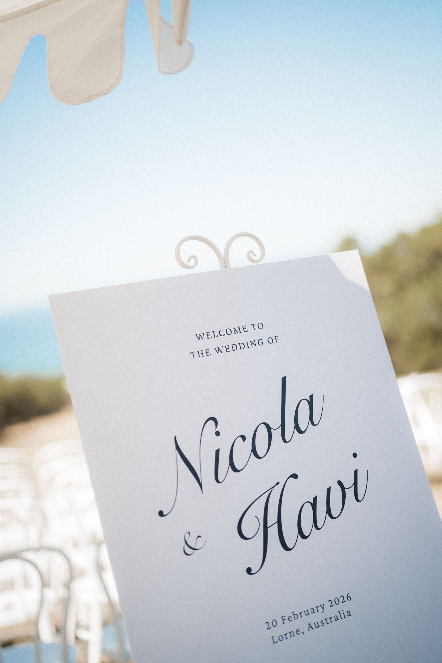 Elegant outdoor wedding welcome sign for Nicola and Havi, February 2026, Lorne Australia, displayed against blue sky.