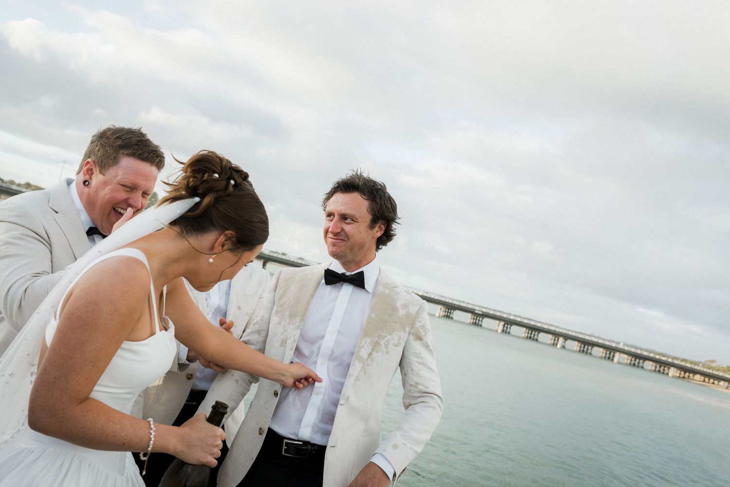 A couple shares intimate moments during their beach wedding celebration with ocean views in the background.