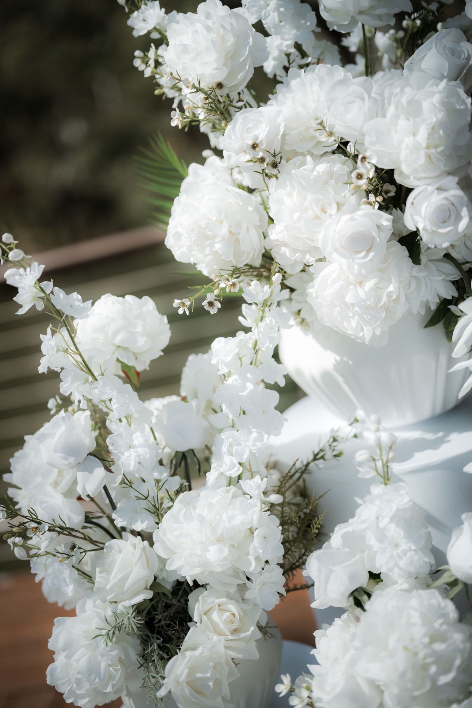 Delicate white roses and baby's breath floral arrangements in soft focus.