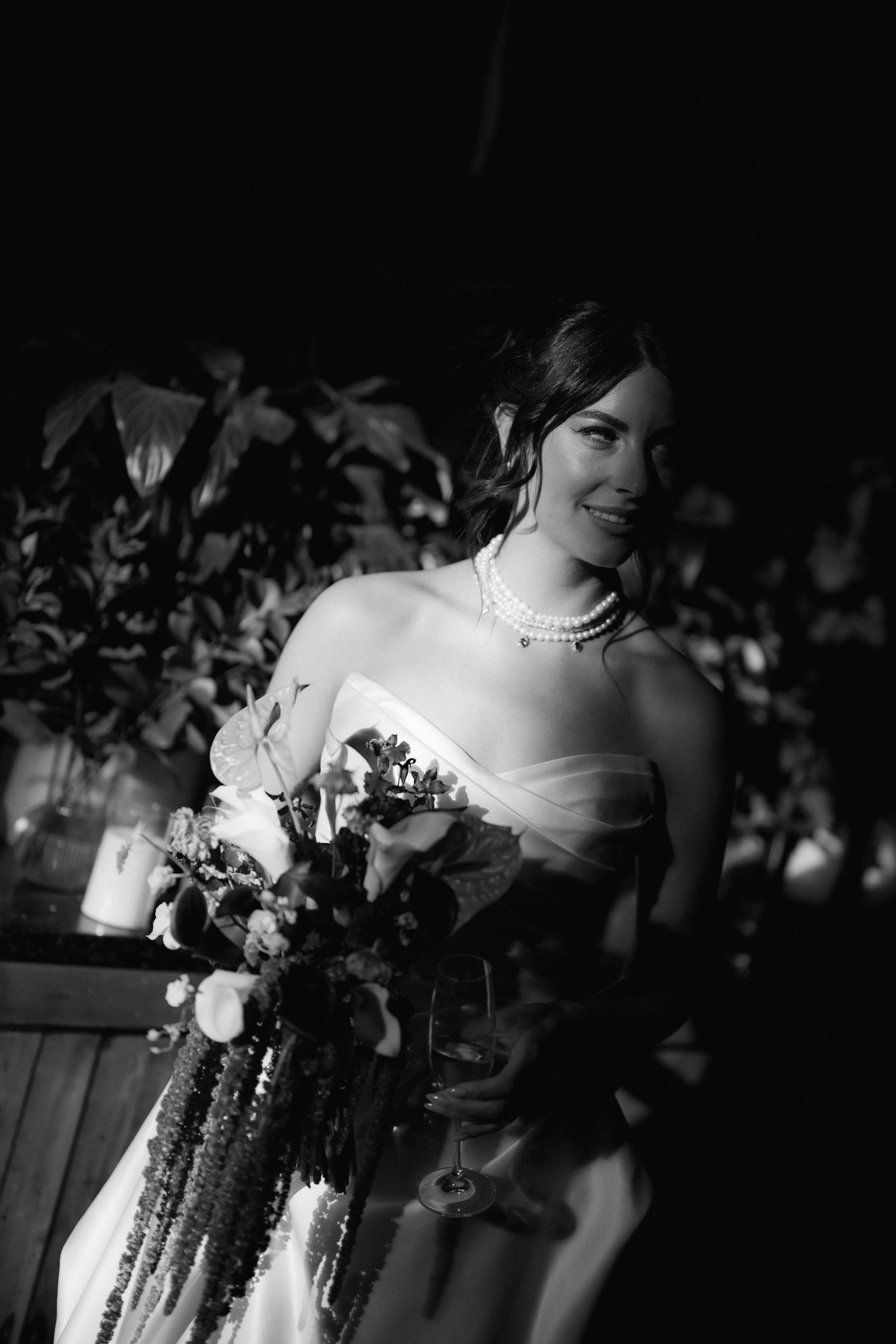 A series of artistic black and white photos showing details of a bride's dress and bouquet at a wedding celebration.
