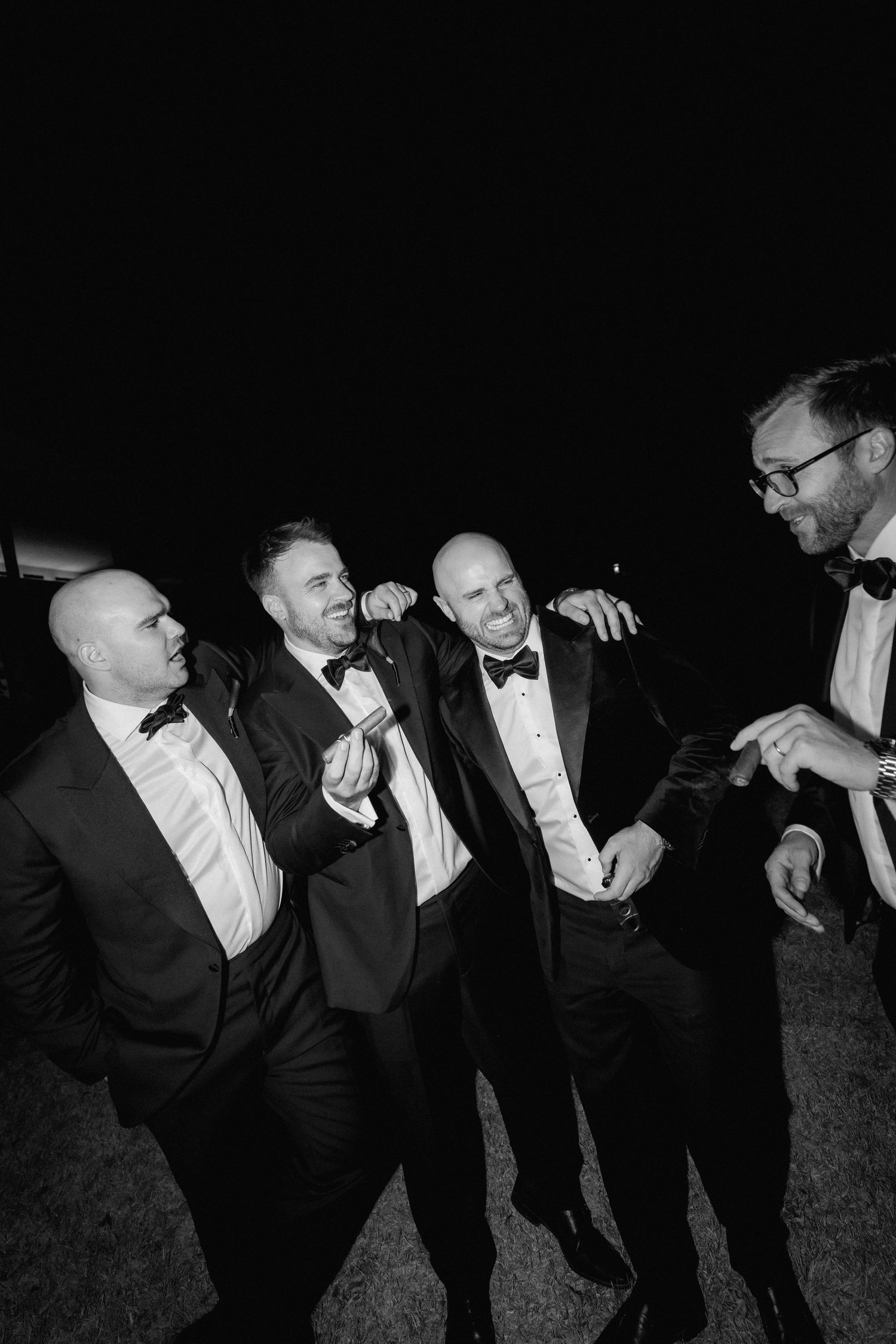 A sequence of black and white photos showing men in tuxedos playfully interacting at a formal event.