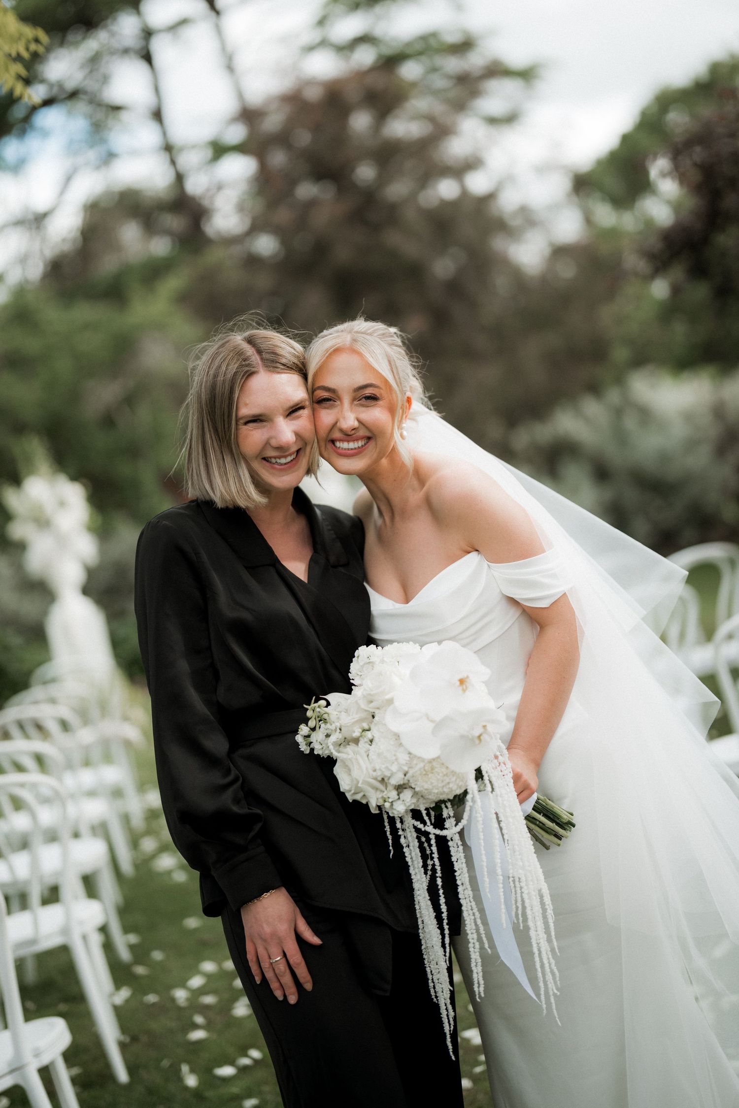 Outdoor wedding scene with white chairs and joyful moments captured in natural lighting.