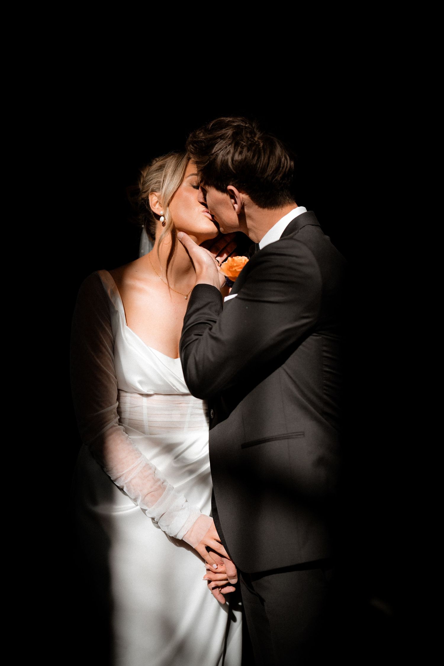 A series of romantic wedding photos showing a couple in white dress and black suit embracing in dramatic lighting.