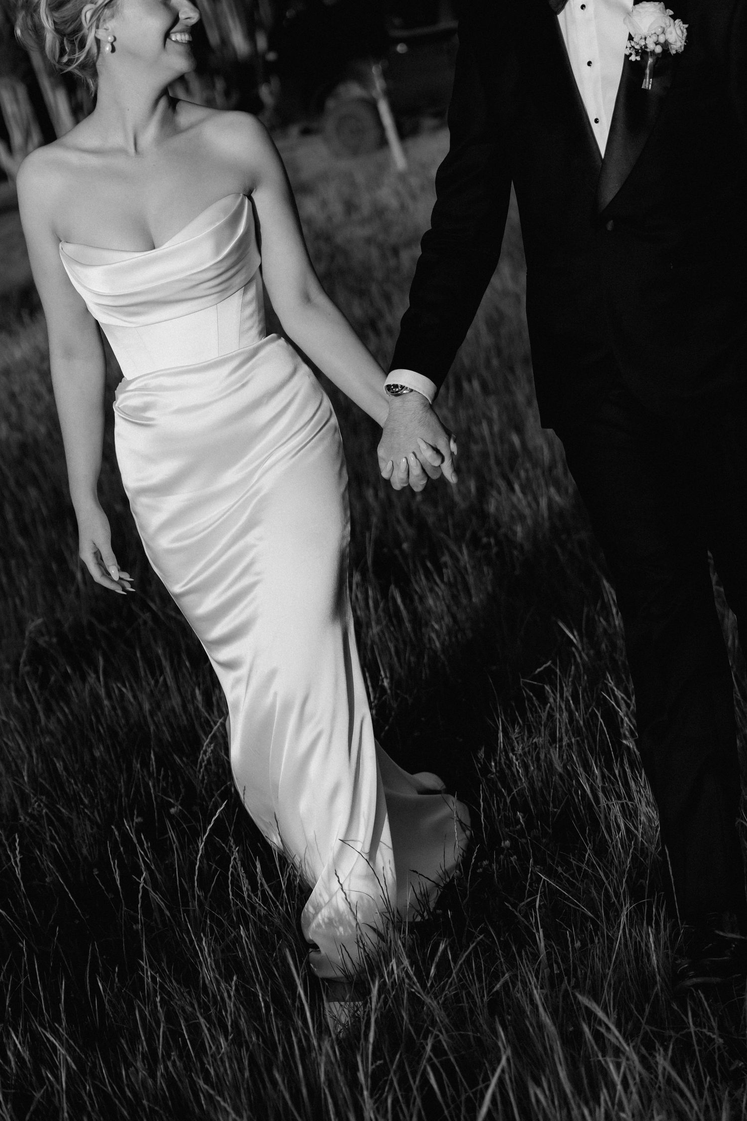 Black and white artistic photo series showing flowing wedding dress details in tall grass.