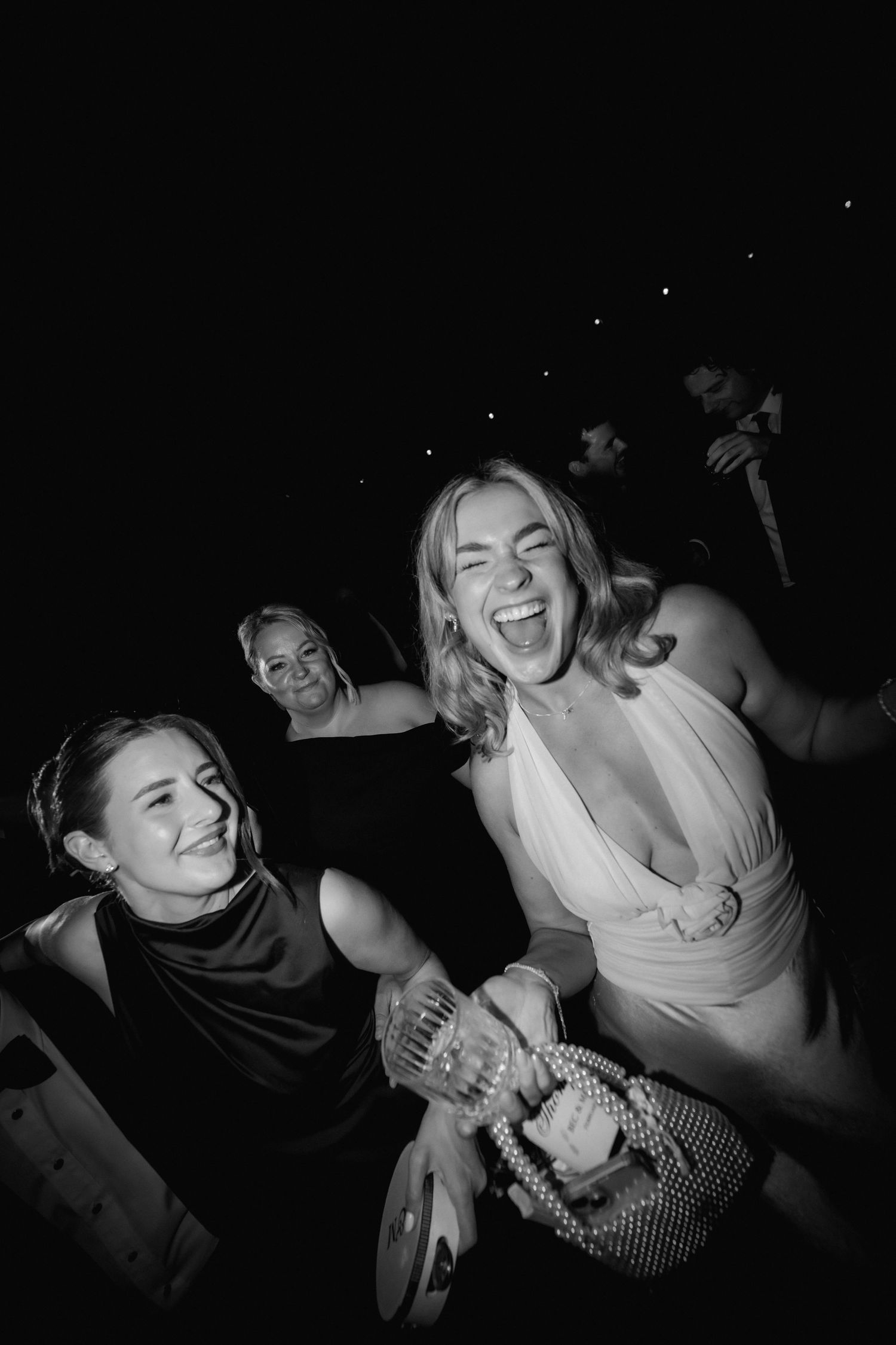 Black and white photos capture joyful dancing and celebration at nighttime party.