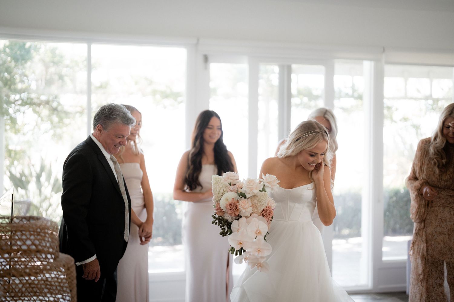 Elegant wedding ceremony setting with bright natural light streaming through large windows.