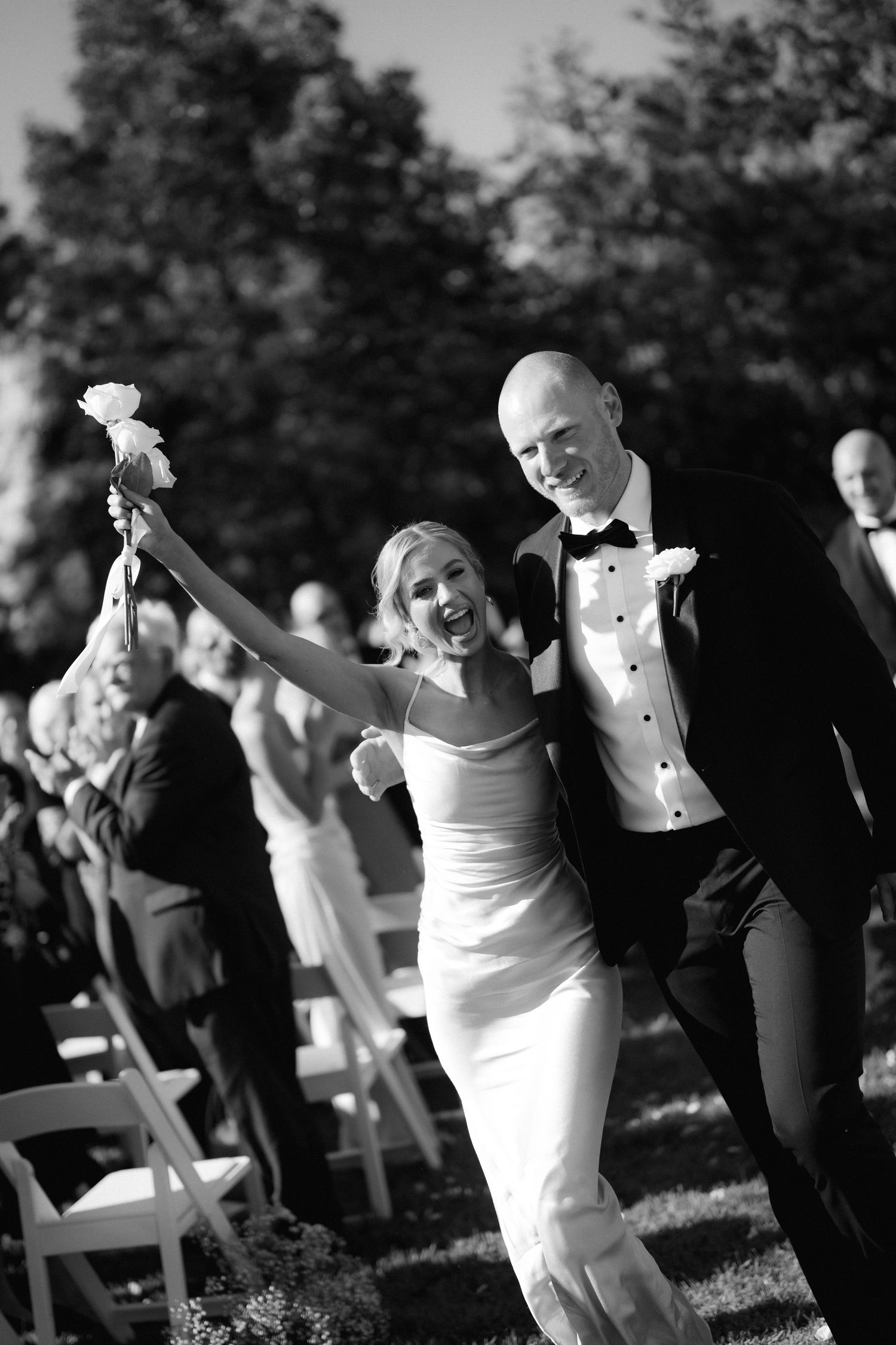 A joyful couple dancing together outdoors during their wedding celebration.