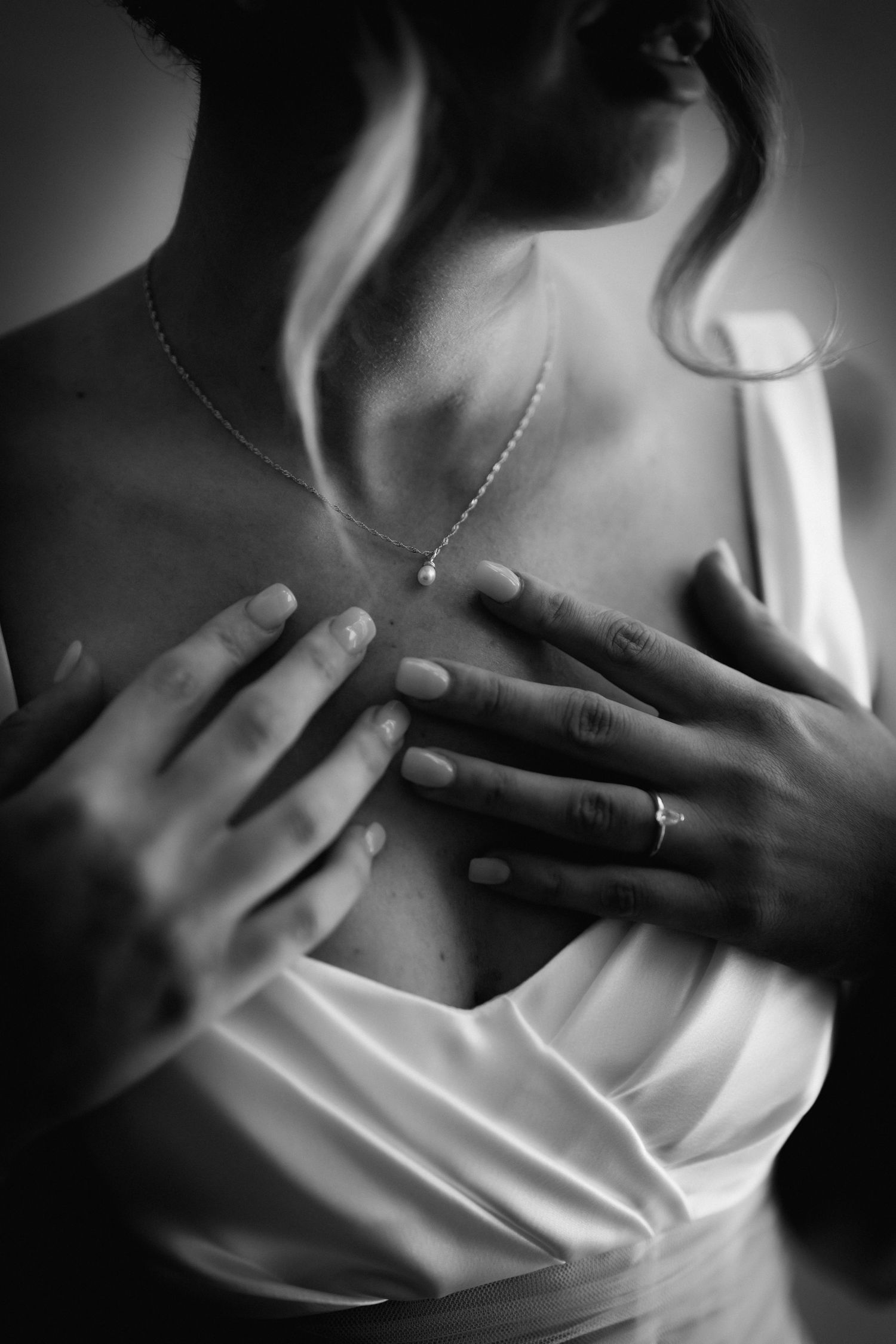 Series of intimate black and white close-up shots showing hands gently touching formal attire.