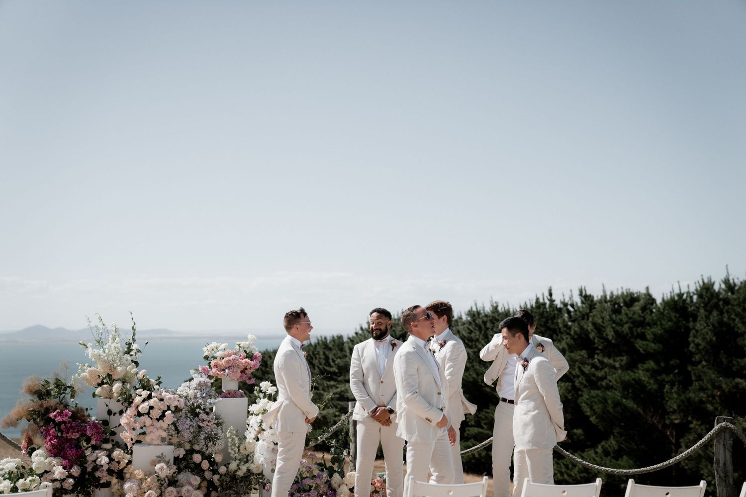 A wedding ceremony setup on a hilltop with scenic mountain views and elegant floral decorations.