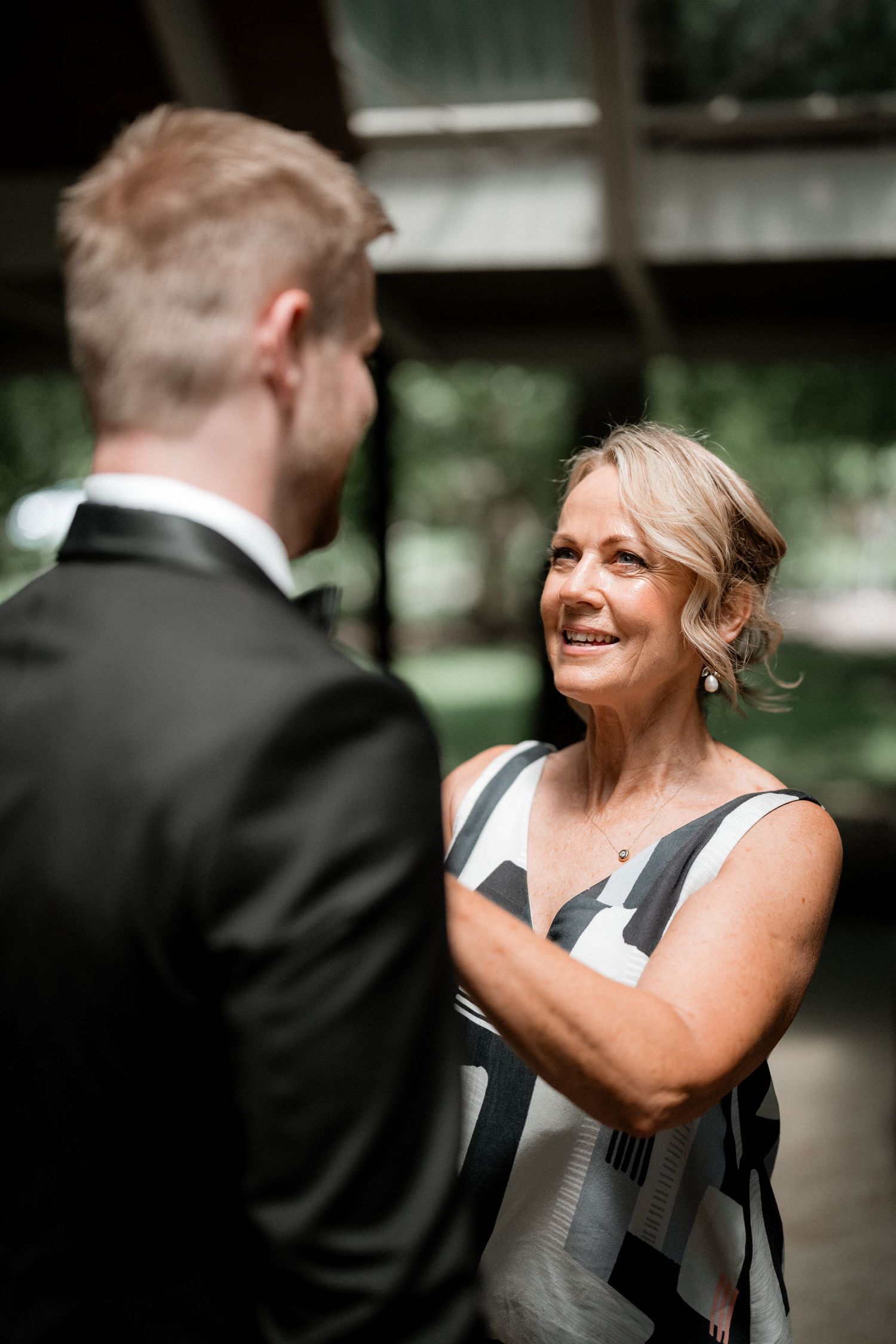 A heartwarming interaction between a guest in a formal suit and someone wearing a gray dress at an elegant event.
