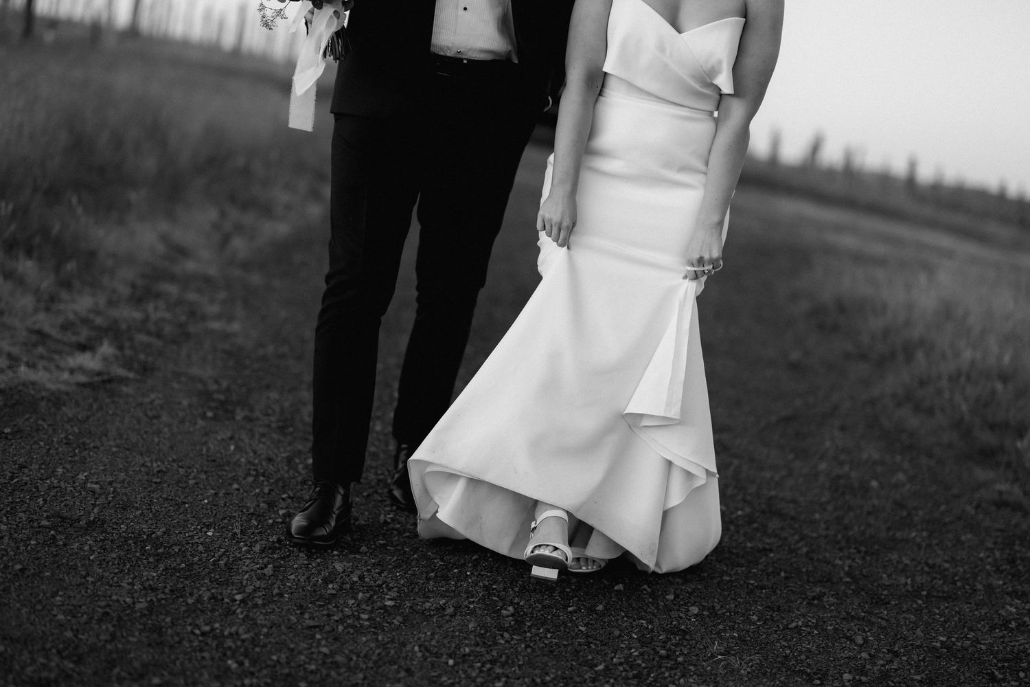 Black and white detail shot of bride and groom's formal wedding attire.