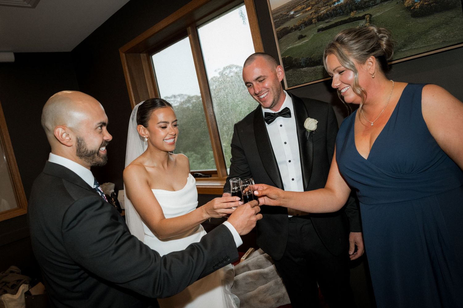 Wedding party celebrates with joyful dancing and toasting during reception festivities.