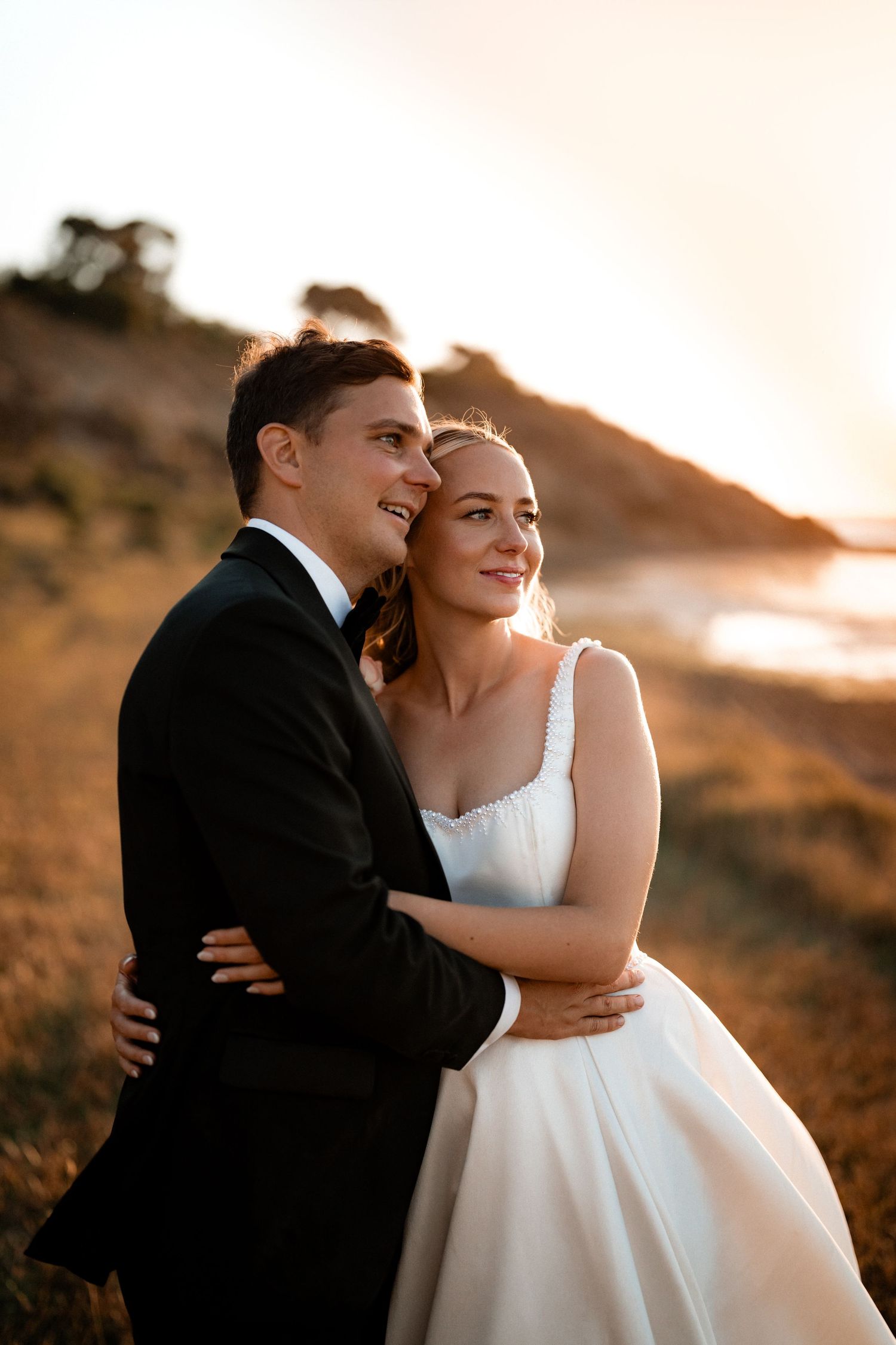 A romantic sunset wedding photo series showing a couple embracing on a hillside in warm golden light.