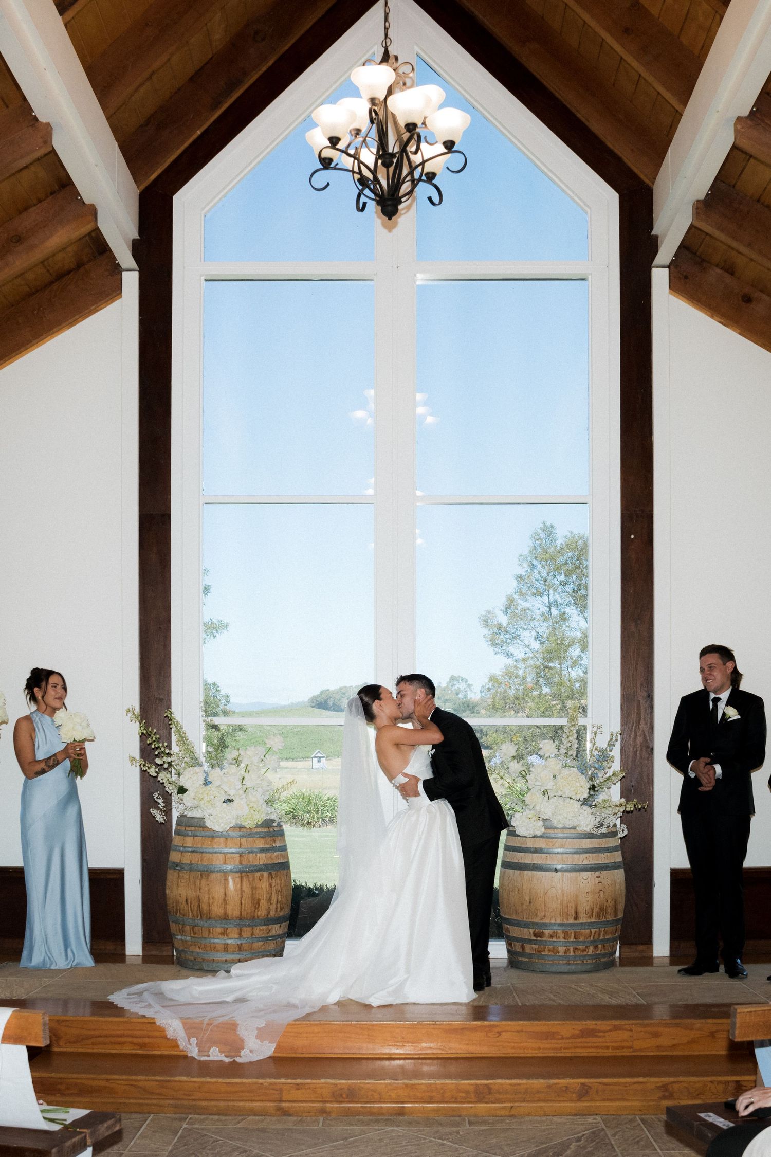 Sequence of playful wedding couple poses in a rustic venue with wooden barrels and vaulted ceiling.