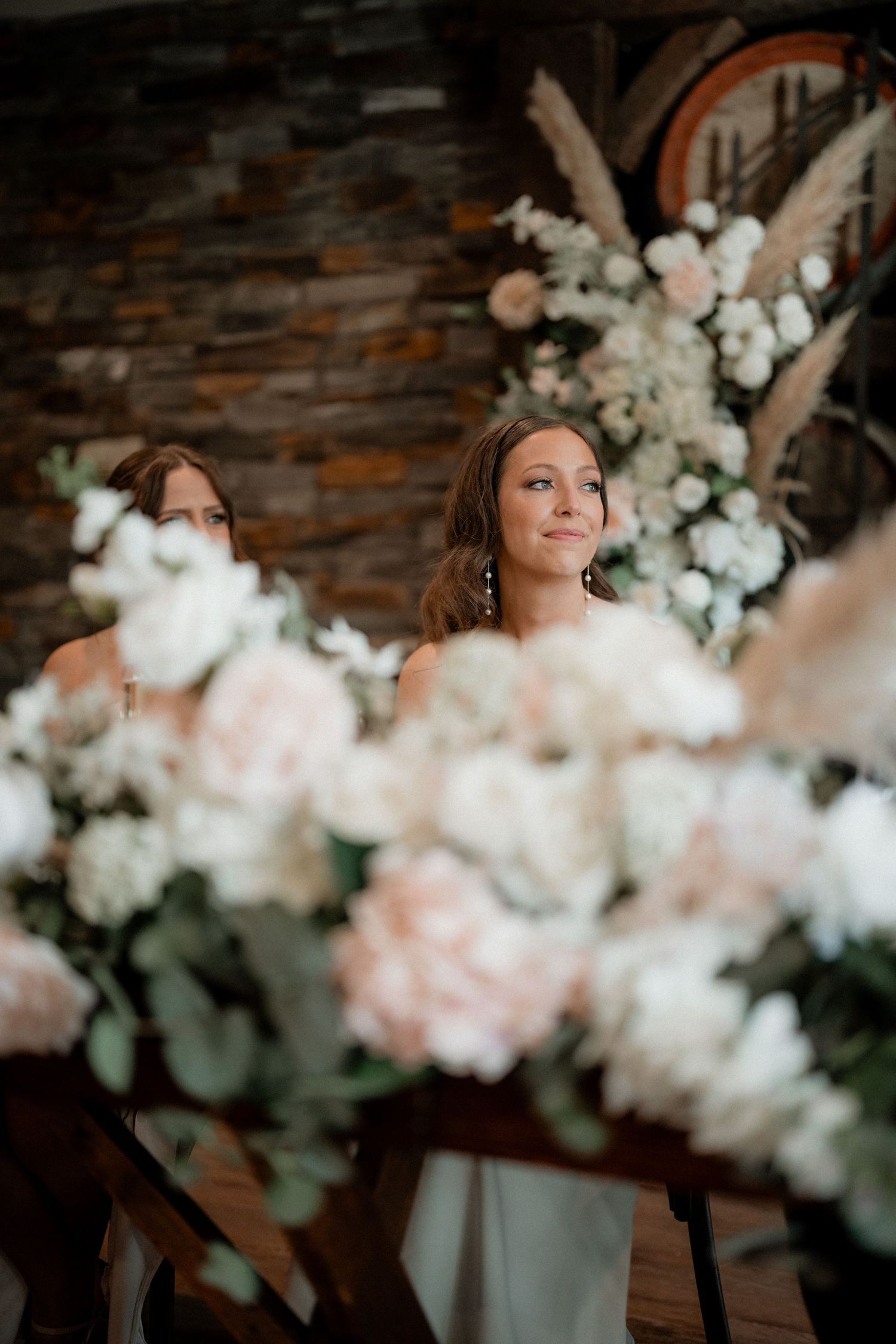 Soft white and pink floral arrangements create an elegant backdrop against a textured wall.