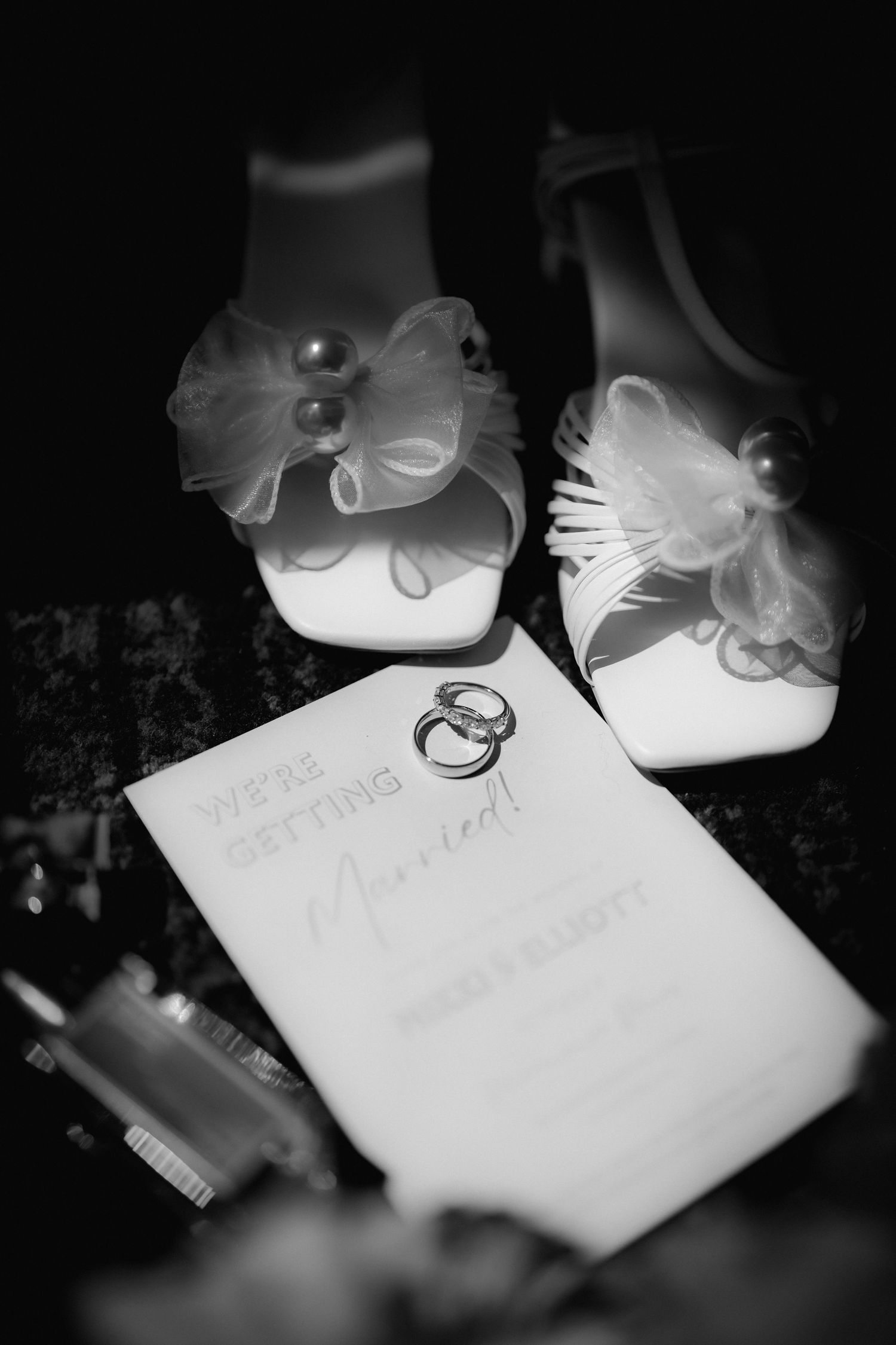 A wedding ring sits on top of a paper document in black and white.