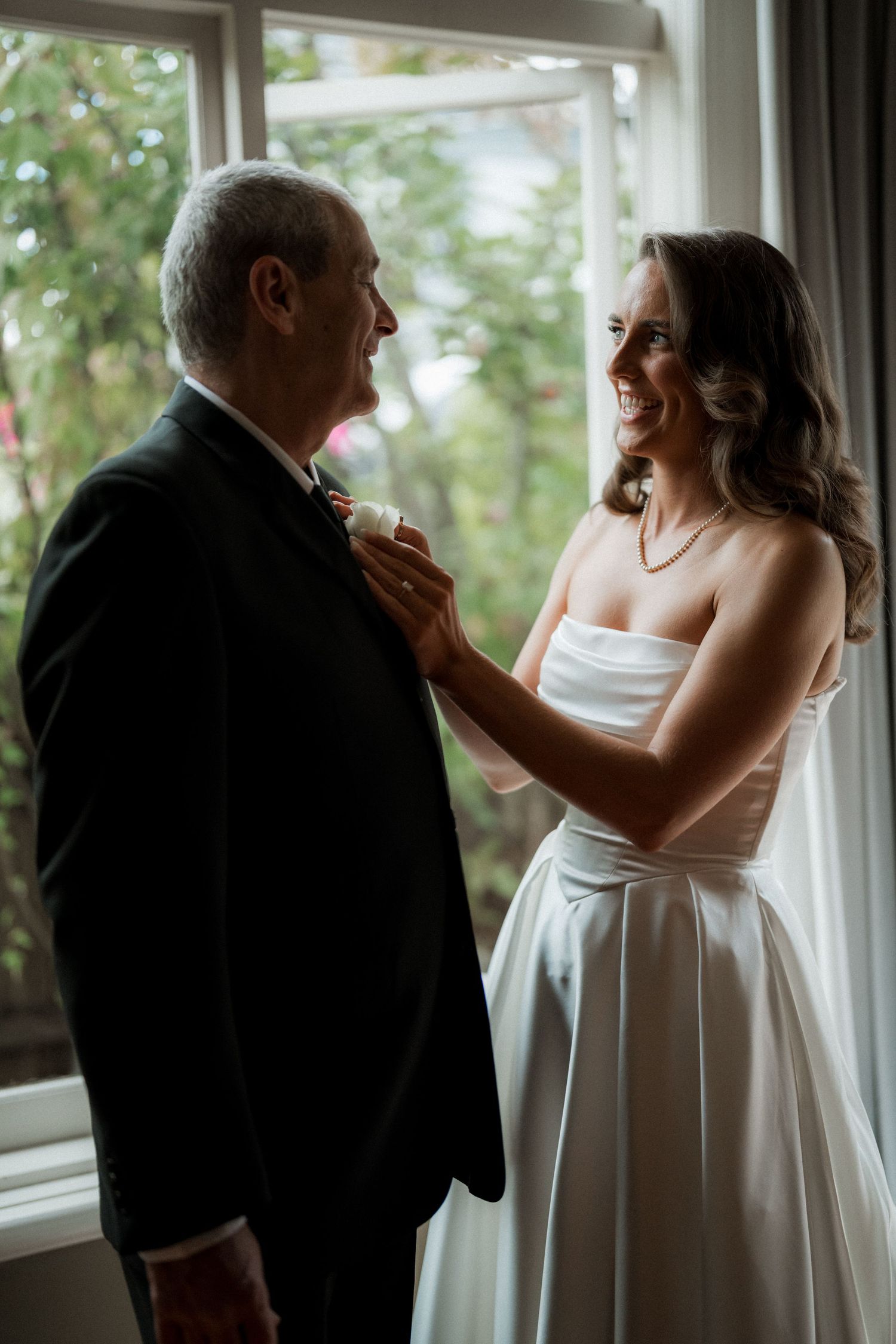 A touching series of candid moments between a bride in white and someone in formal attire by a window.