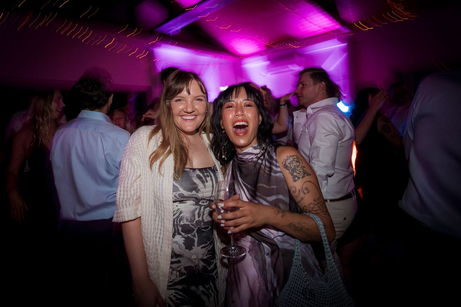 Wedding reception dance floor illuminated with vibrant purple lighting.